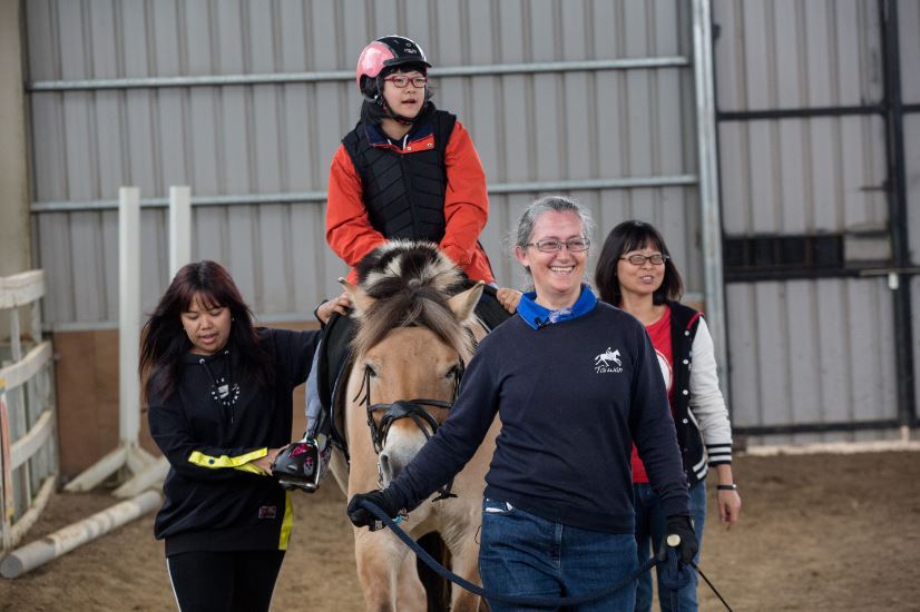 12歲的陳又境接受馬術治療9年了，陳爸爸說，女兒每次下馬後，背部挺直的能力增強許多，馬療對她背部肌肉的發展和支持力很有幫助。