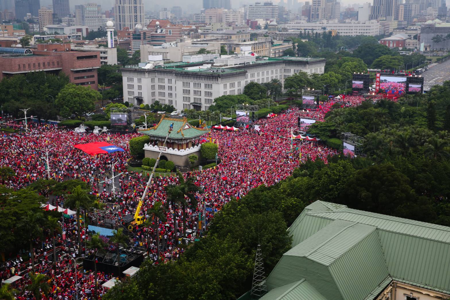 現場下起傾盆大雨，韓粉熱情不退，撐起雨傘，一邊吶喊「風雨生信心」、「韓國瑜凍蒜」、「遇水則發」。