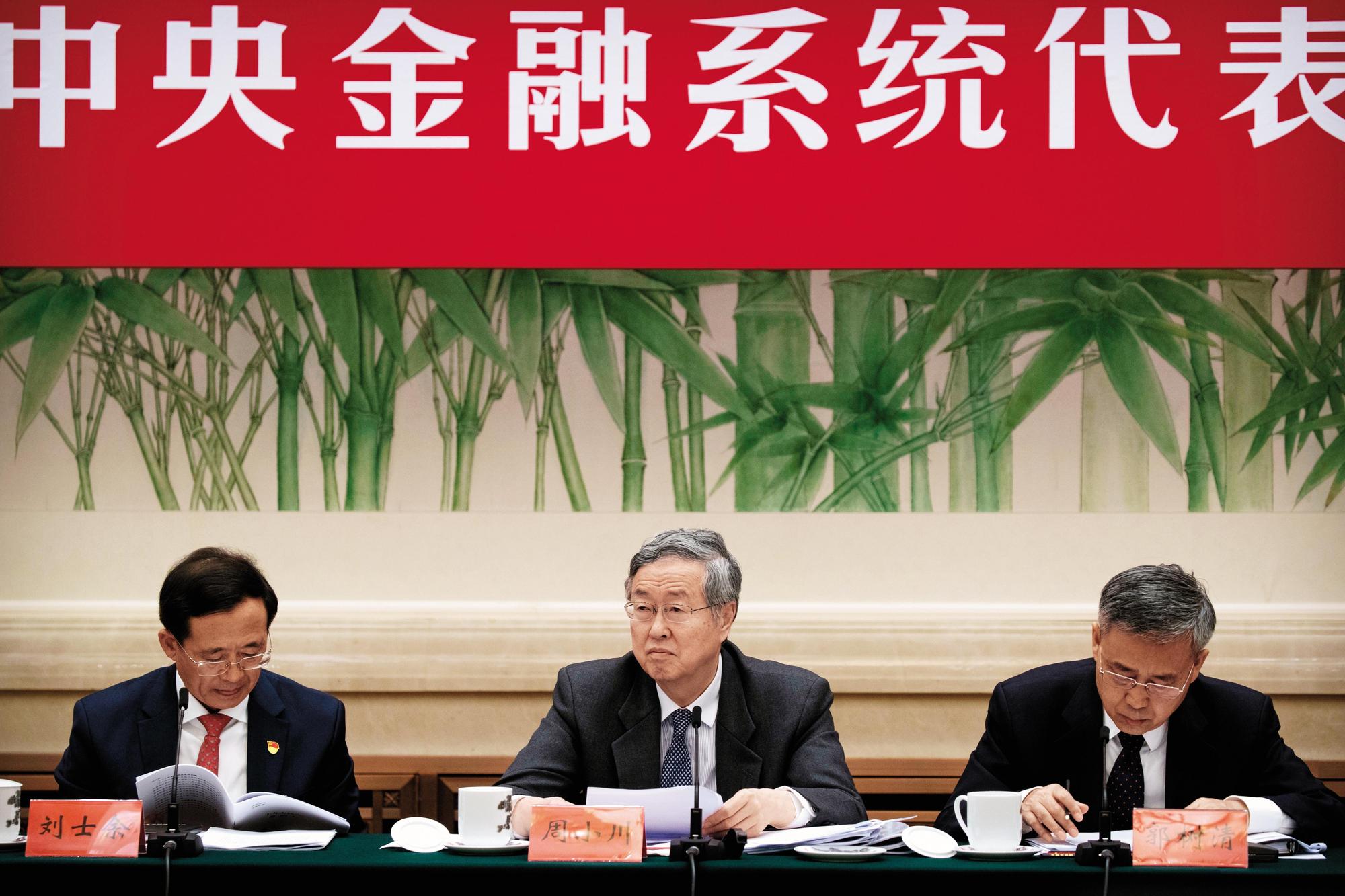 中國人民銀行行長周小川（中）表示，人民幣不會死守7的整數關卡，放手貶值提高出口競爭力的心態明顯。（東方IC）