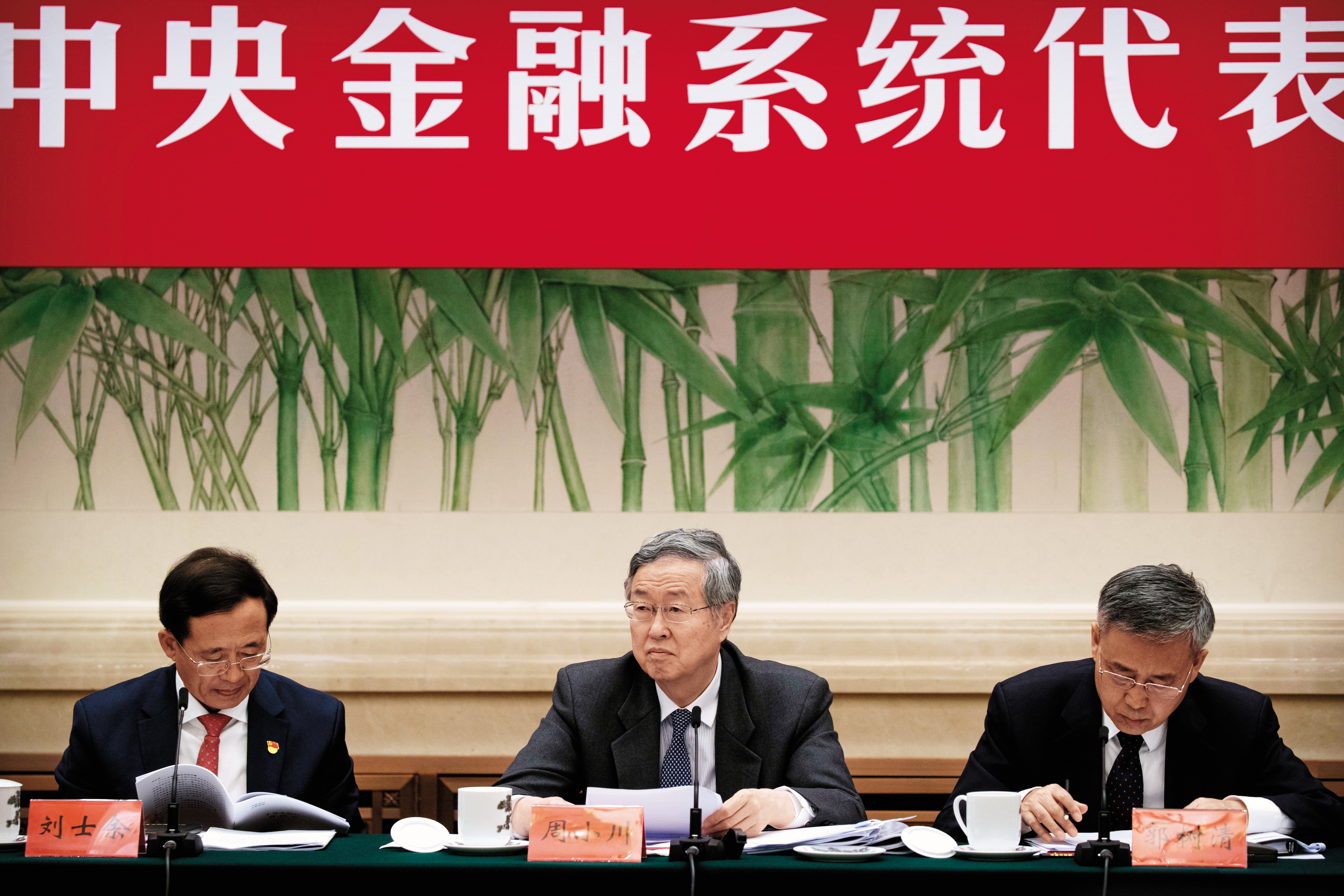 中國人民銀行行長周小川（中）表示，人民幣不會死守7的整數關卡，放手貶值提高出口競爭力的心態明顯。（東方IC）