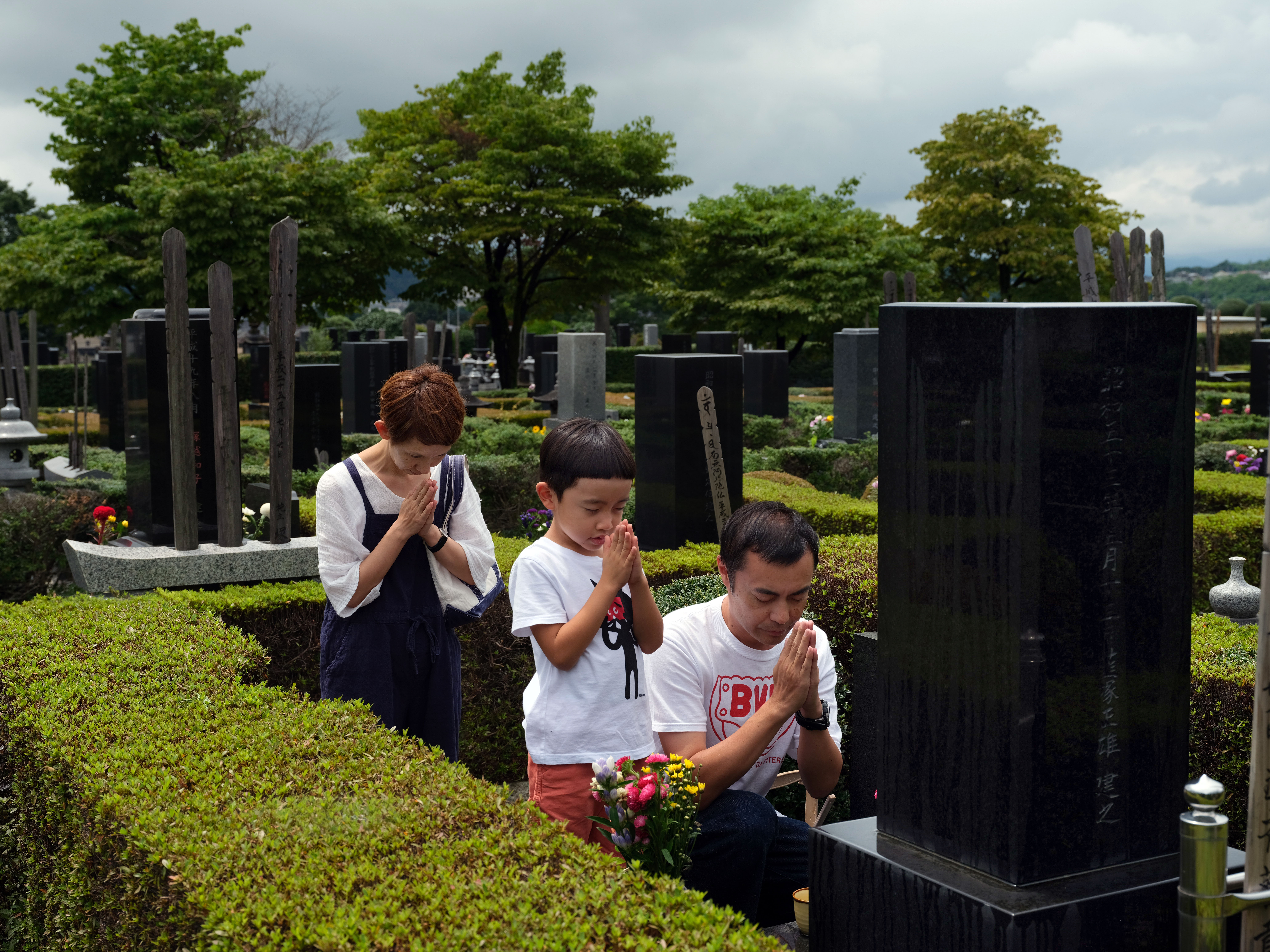 圖為日本一小家庭的掃墓情景。（東方IC）