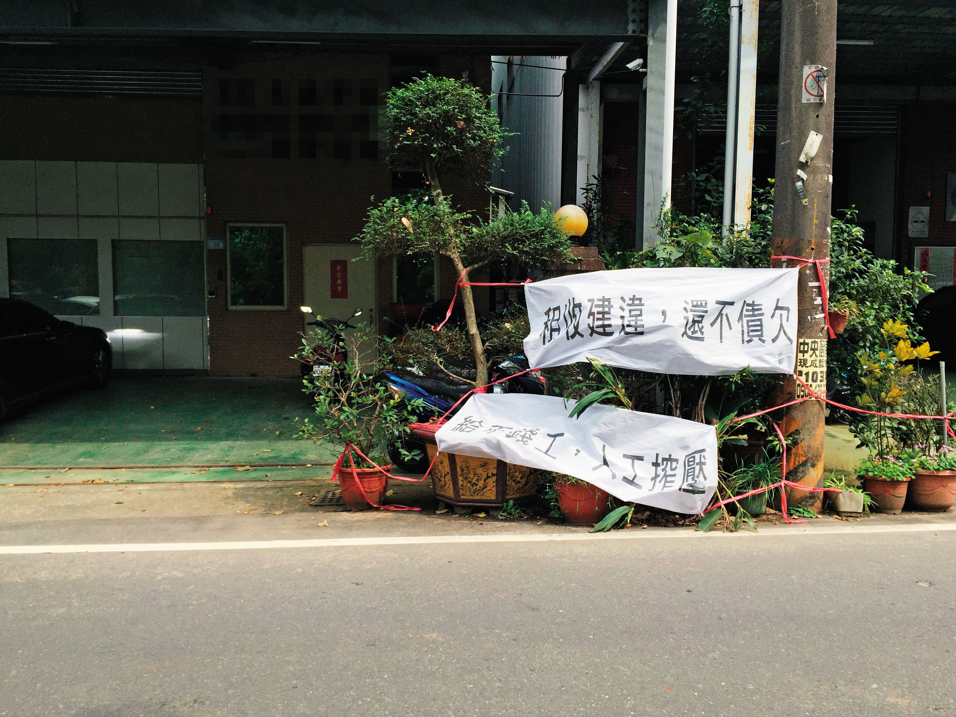 簡漢武等人在被害人公司門口拉布條討債。(翻攝畫面)