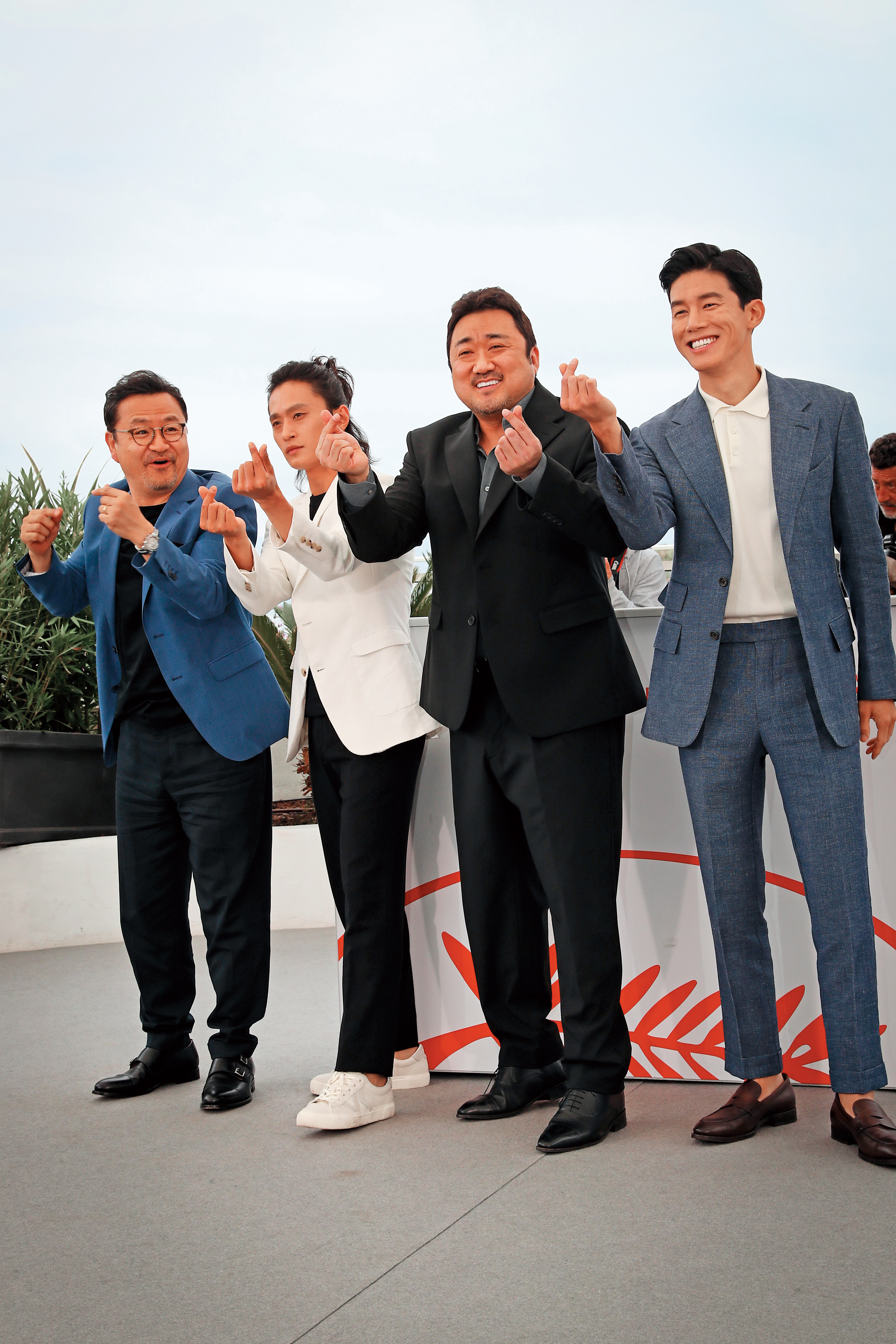 《極惡對決》在本屆坎城影展午夜放映單元受到觀眾歡迎,導演李元泰(左起)率演員金成圭、馬東石與金武烈比手指愛心。(東方IC)