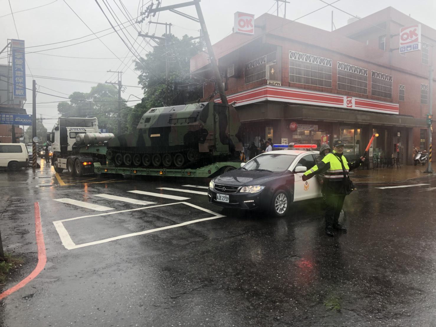 拖板車司機載送坦克時，不慎勾倒一旁電桿。（翻攝畫面） 