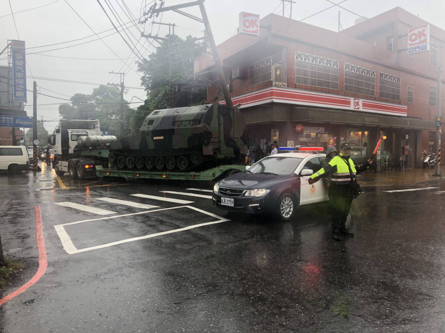拖板車司機載送坦克時，不慎勾倒一旁電桿。（翻攝畫面） 