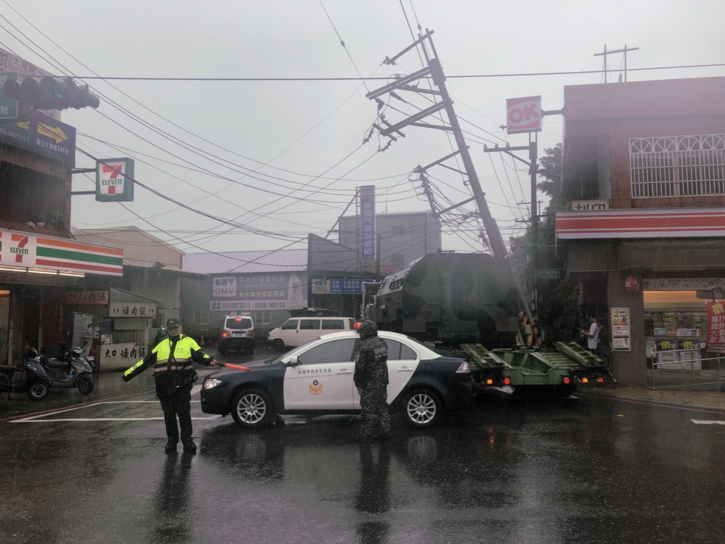 拖板車司機載送坦克時，不慎勾倒一旁電桿。（翻攝畫面）