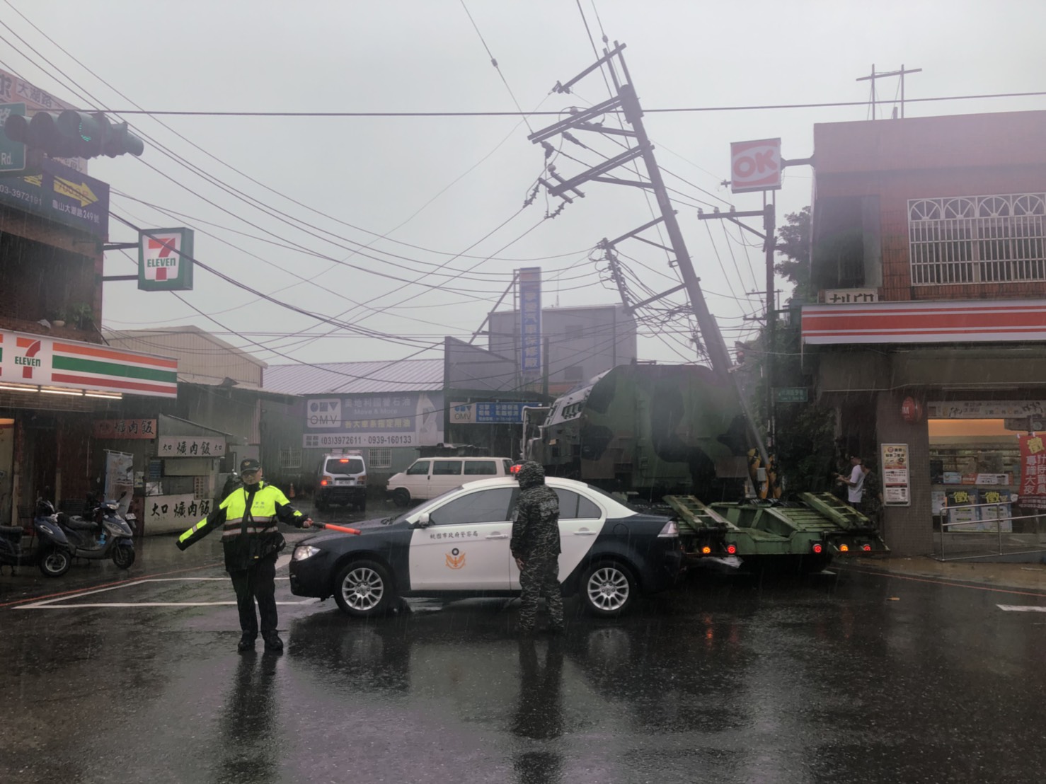 拖板車司機載送坦克時,不慎勾倒一旁電桿。(翻攝畫面)