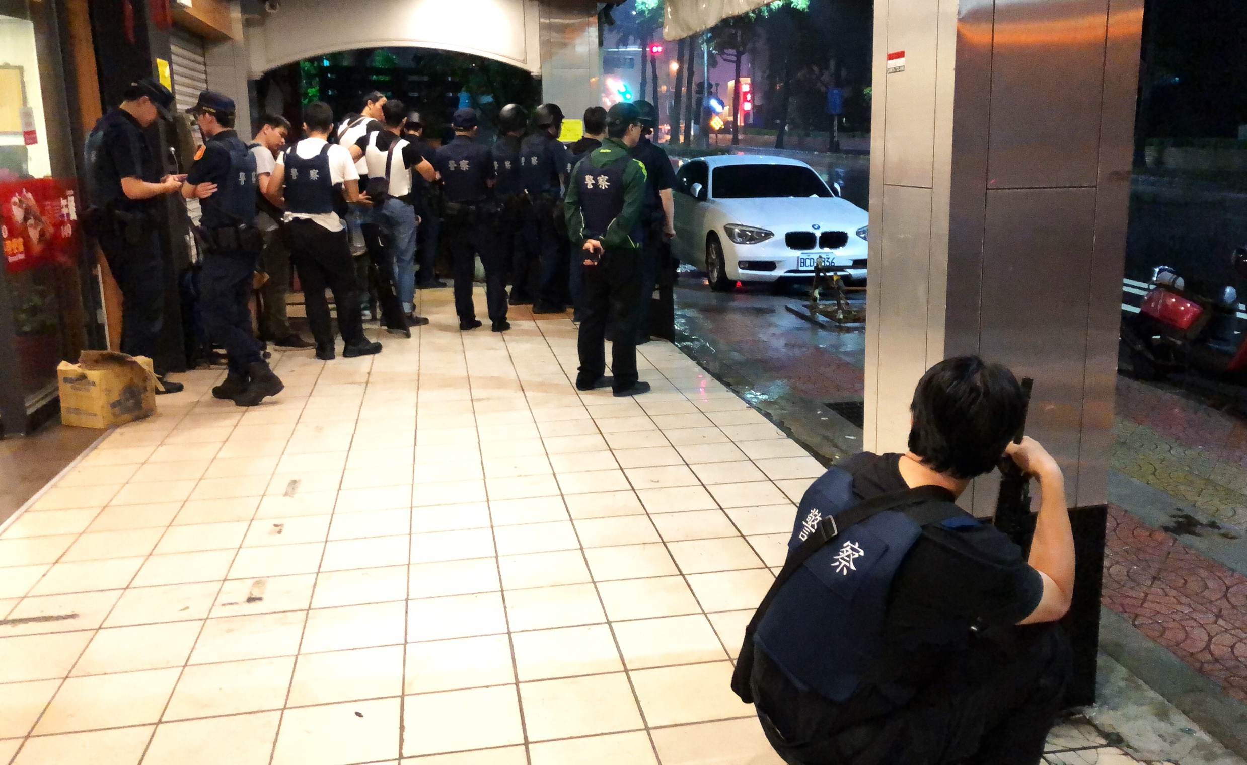 警方獲報後,在二手車行前與嫌犯對峙,並持續溝通中。(翻攝畫面)