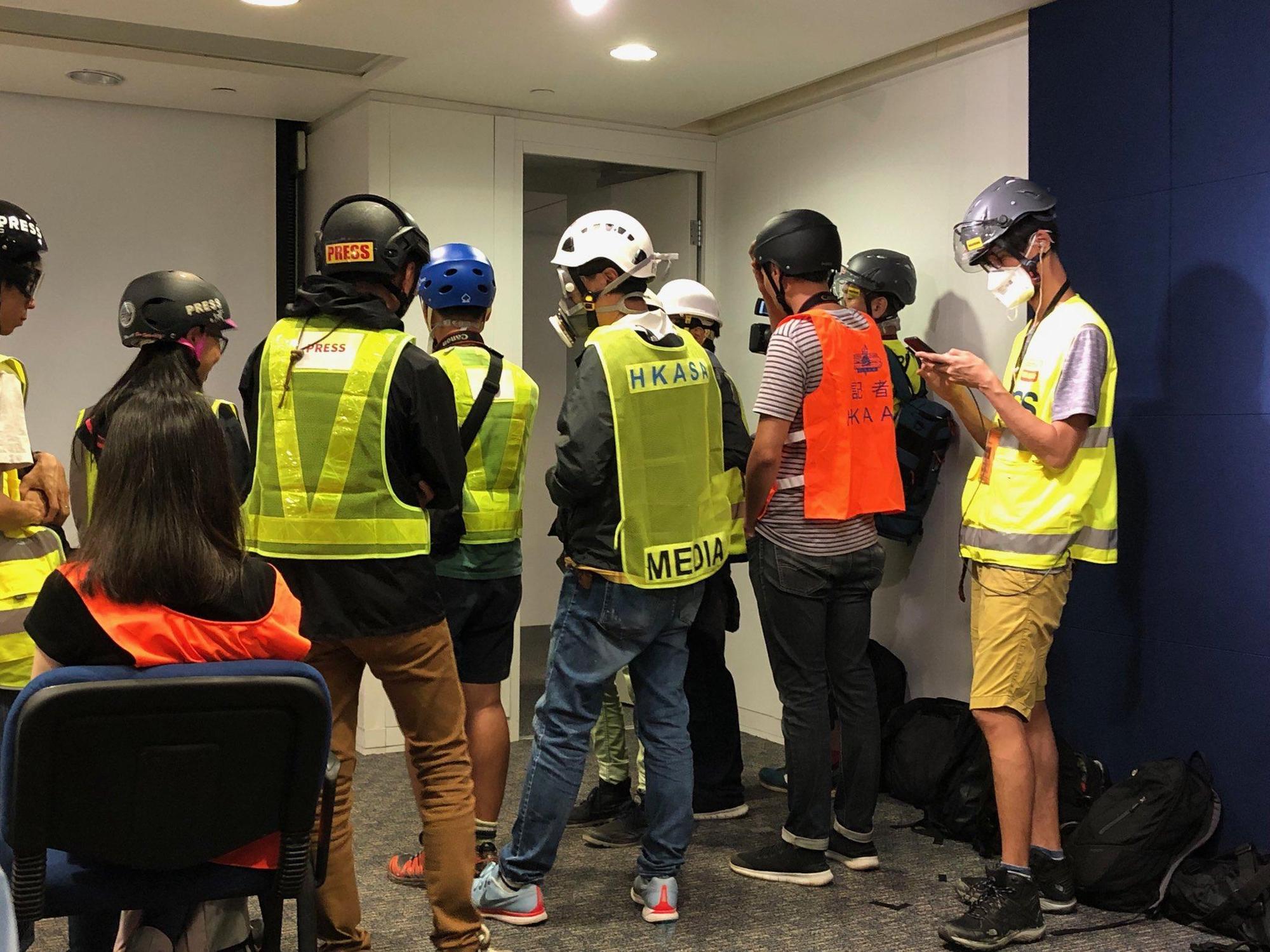 香港記者響應戴頭盔、穿反光背心和防毒面罩出席記者會，抗議警察暴力。（翻攝自JSolomonHK推特）