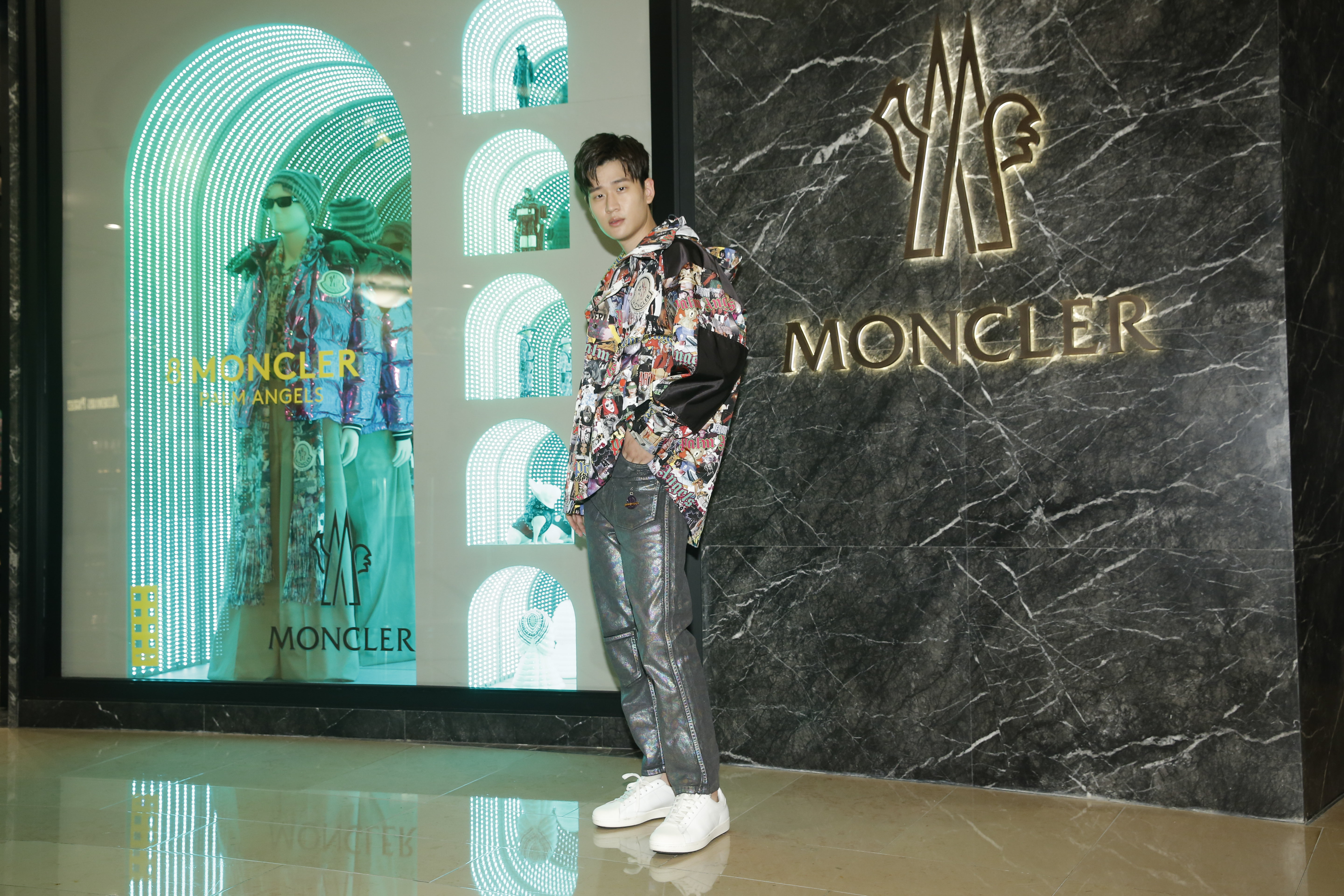 周興哲穿著8 MONCLER PALM ANGELS塗鴉印花夾克NT$58,500、黑色Logo上衣NT$18,500、金屬光黑色直筒長褲NT$13,600。