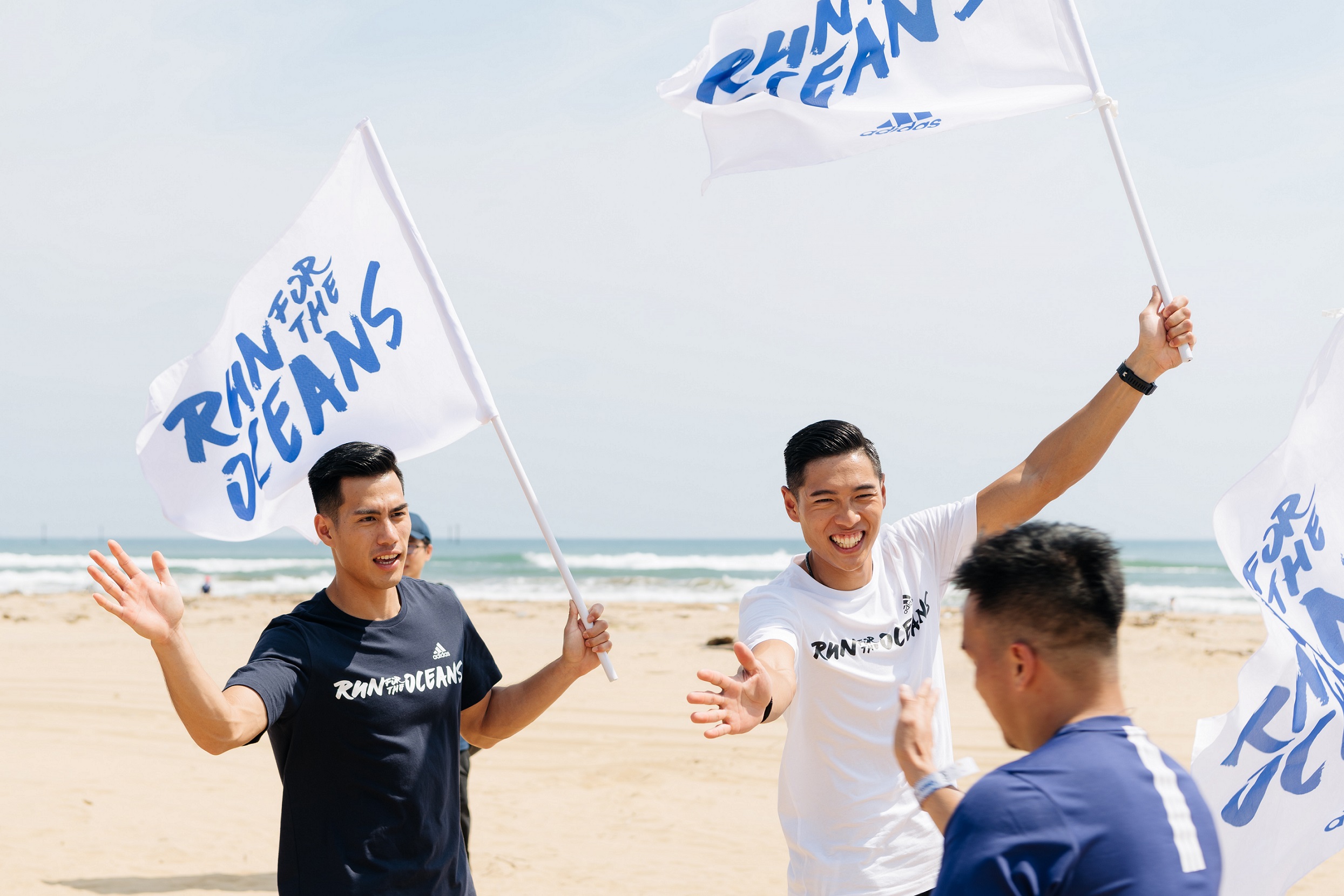 楊俊瀚(左)、陳傑在路跑終點,跟跑者擊掌加油打氣。(adidas提供)