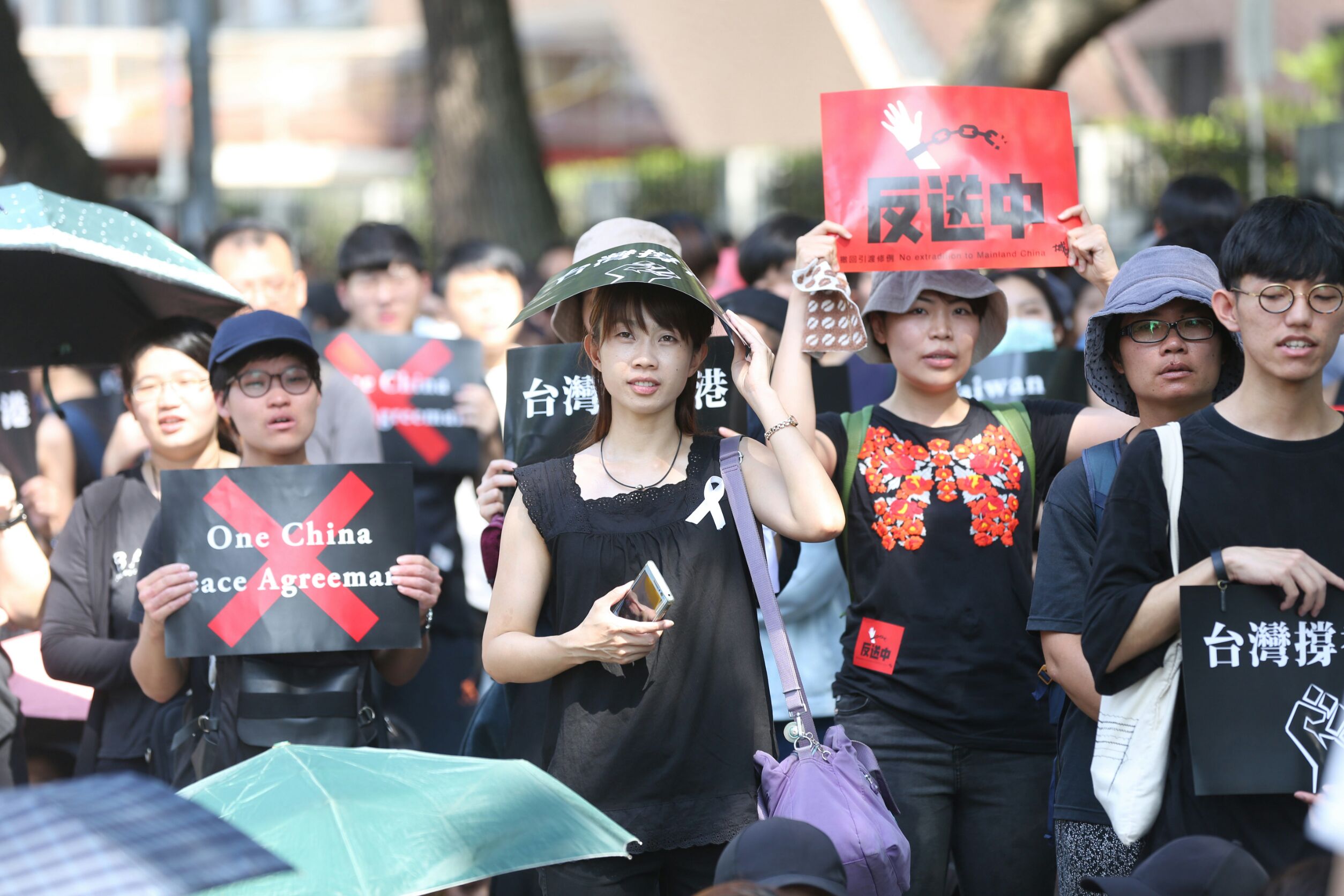 現場民眾除了身穿黑衣綁上白絲帶,紛紛舉起「台灣撐香港」「反送中」等標語。