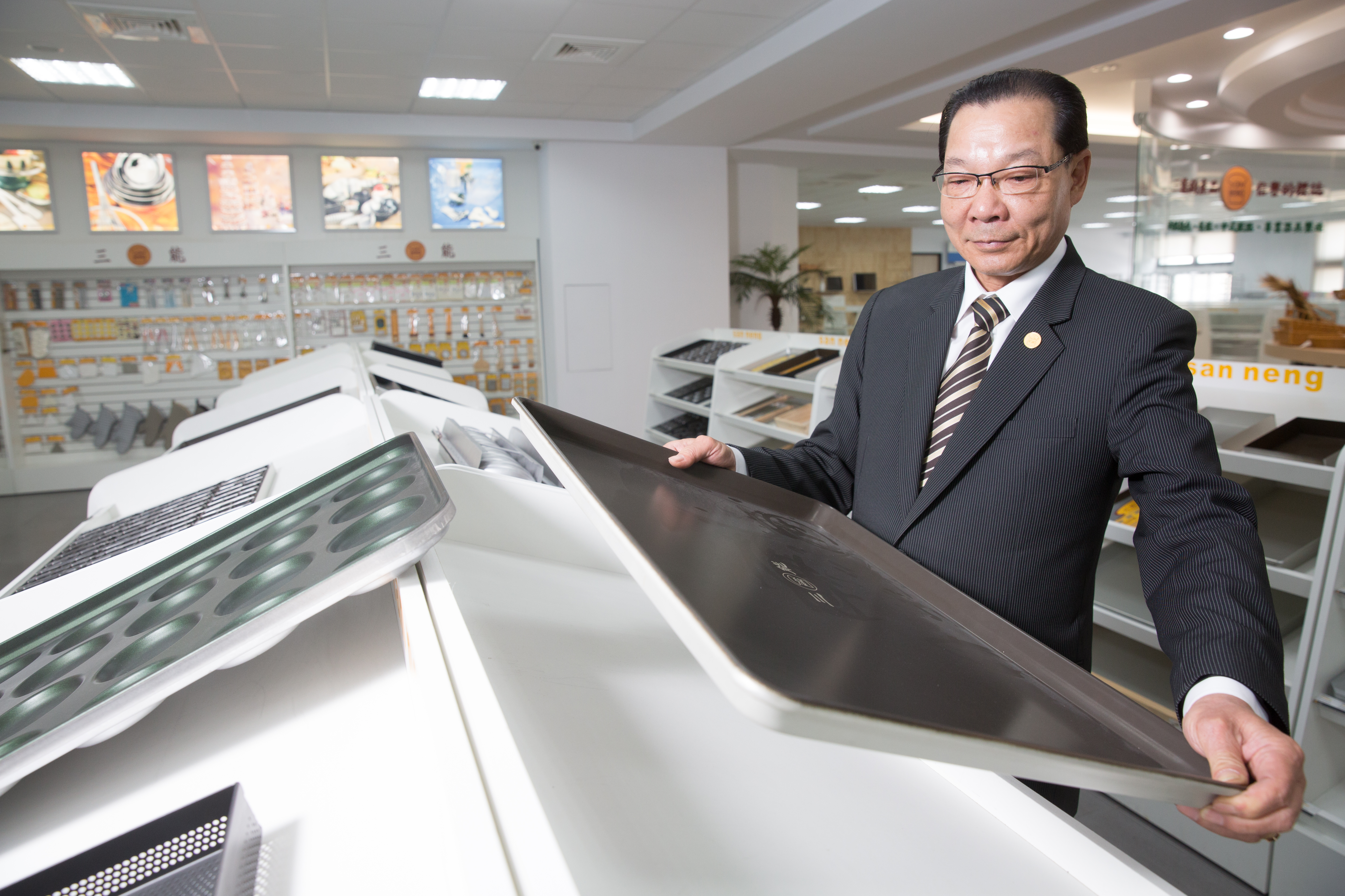 張瑞榮展示自家烤盤時，一邊說明當年手工製作的辛苦過程。