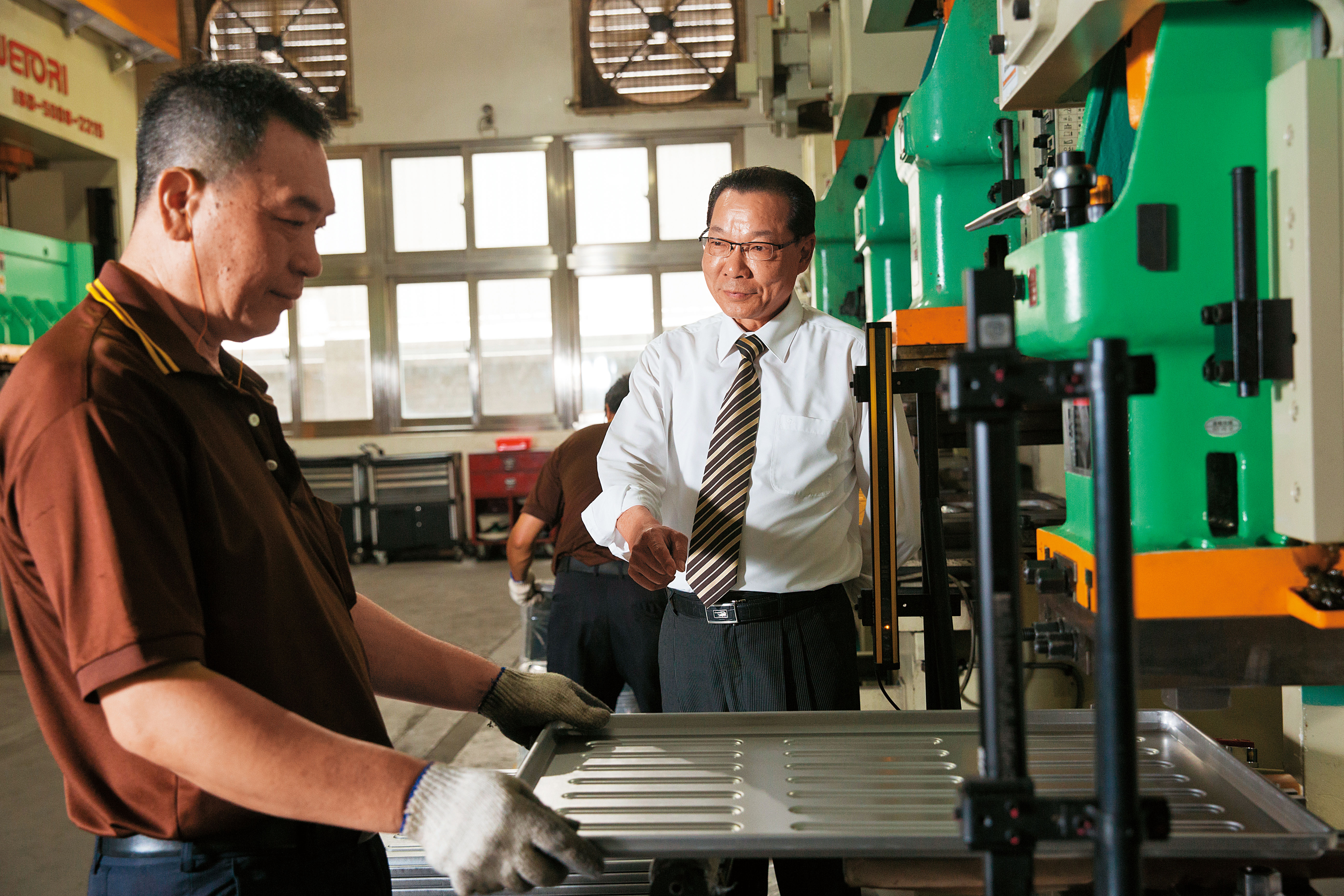 三能集團總裁張瑞榮（右）白手起家，三能目前已是亞洲最大烘焙器具廠，位在台中大里的廠房占地一千八百坪，主要研發與製造烤盤與吐司盒。