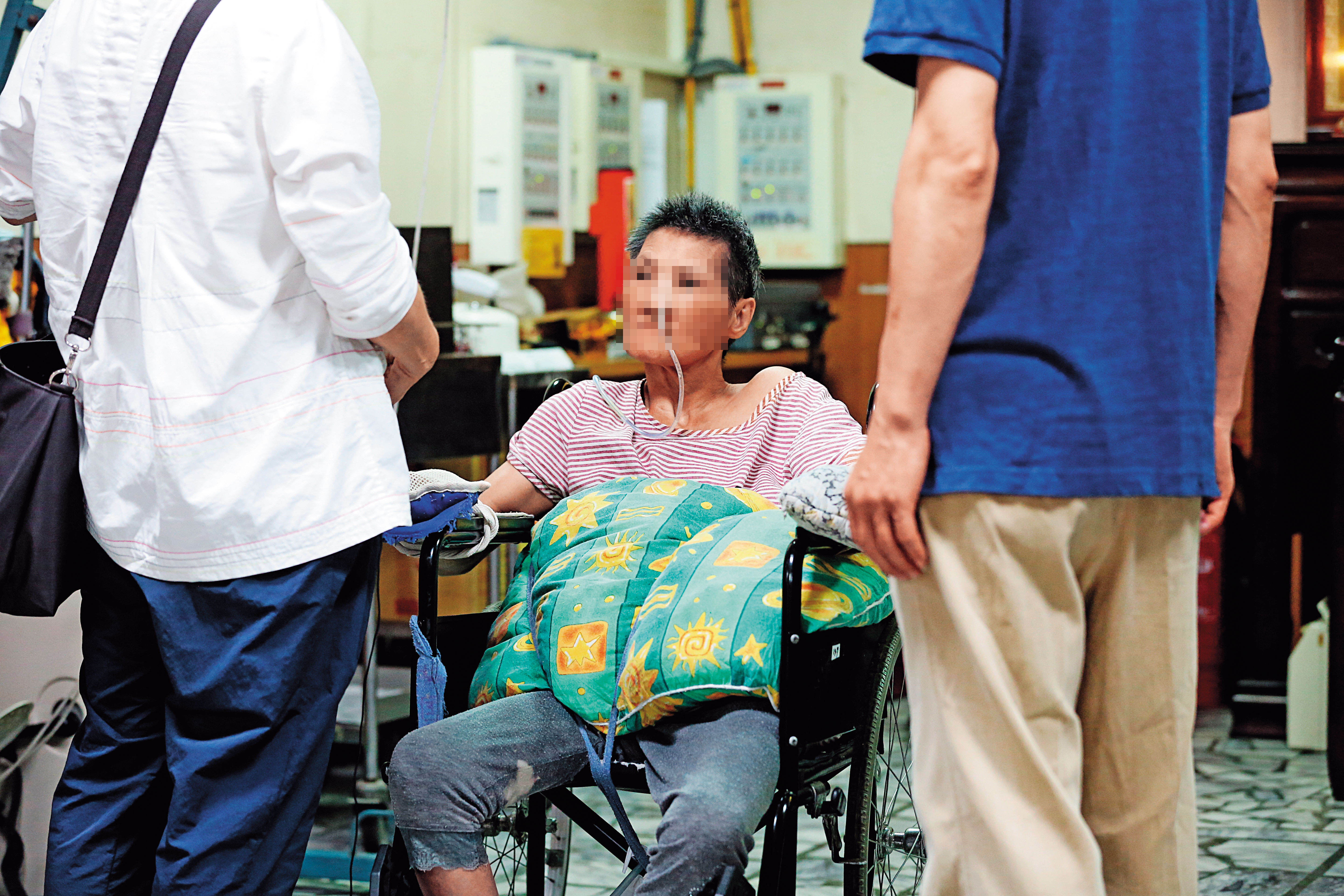 四肢捲曲癱瘓的張女，由家屬陪同，控訴母親和醫院餵服強效精神藥物謀財。