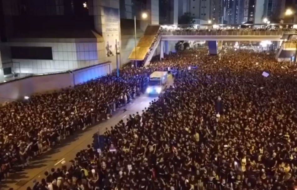 網路上流出香港616反送中大遊行影片，當有救護車經過時，遊行人士井然有序地讓出道路讓救護車通行，宛如現代版「摩西分黑海」。（翻攝自YouTube）