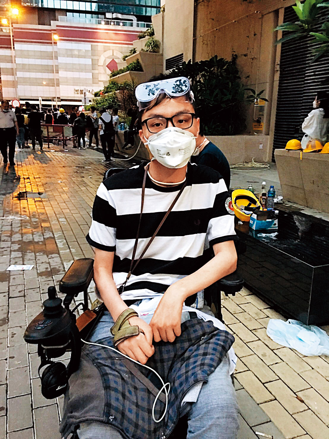 劉小明胸部以下癱瘓，仍堅持在群眾後方支持運動。（曾芷筠攝）