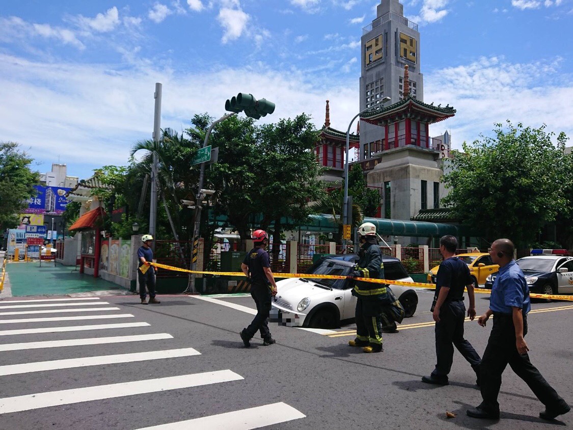 名車陷入坑洞，現場拉起封鎖線。（翻攝畫面）