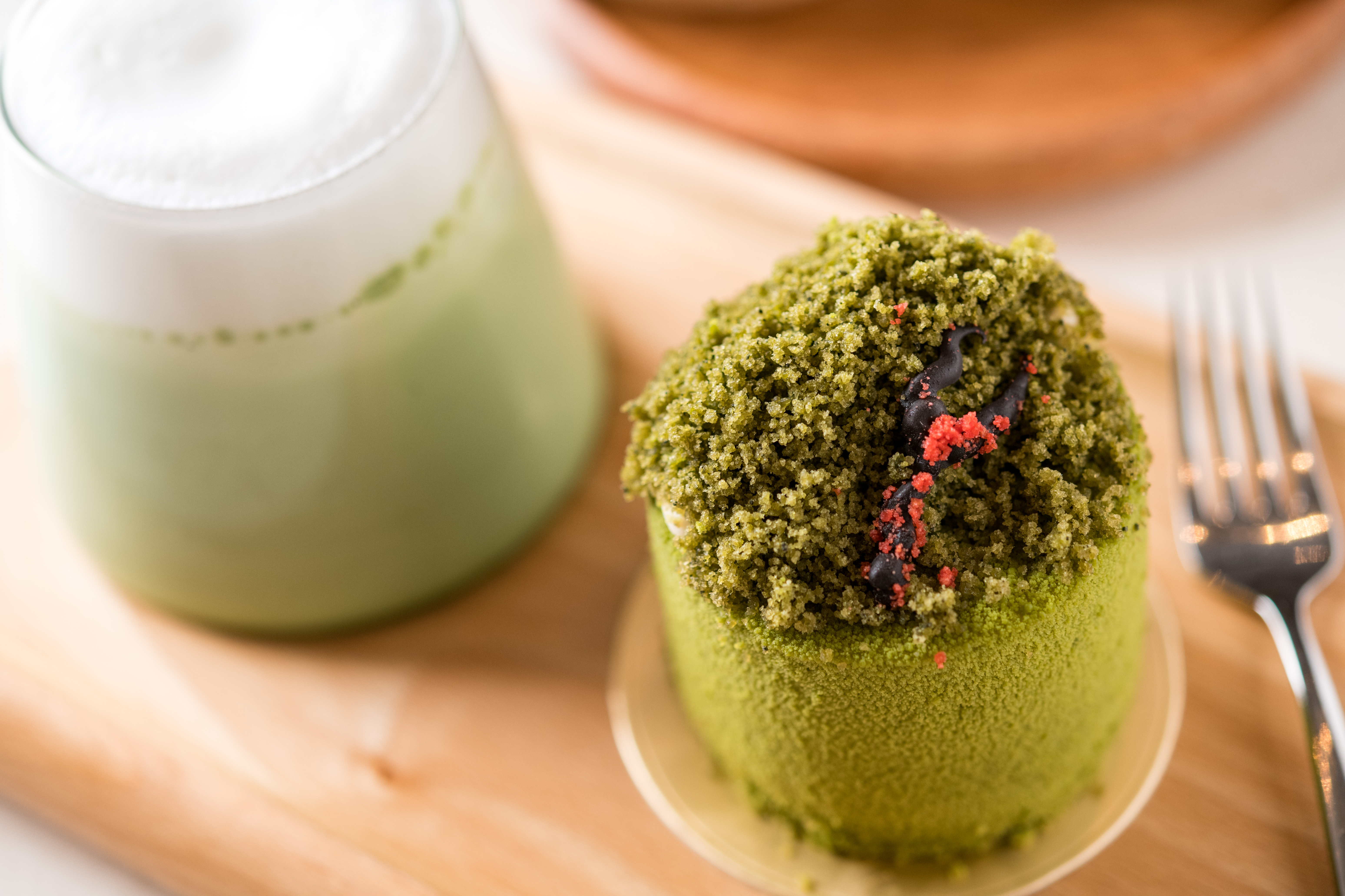 「抹茶拿鐵」（後，180元／杯）搭配「五峰抹茶山蛋糕」（前，150元／份），蛋糕上還以巧克力布置成抹茶山上的山徑。