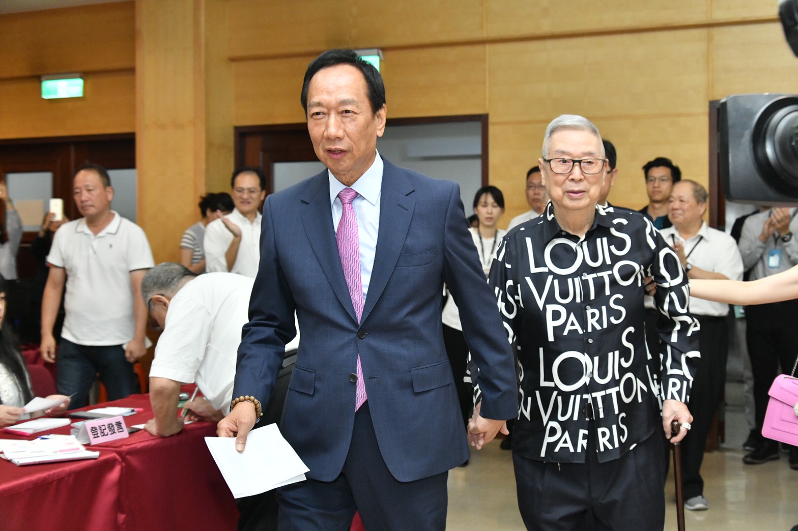 郭董手牽著資深股民阿土伯踏進股東會現場。（鴻海提供）