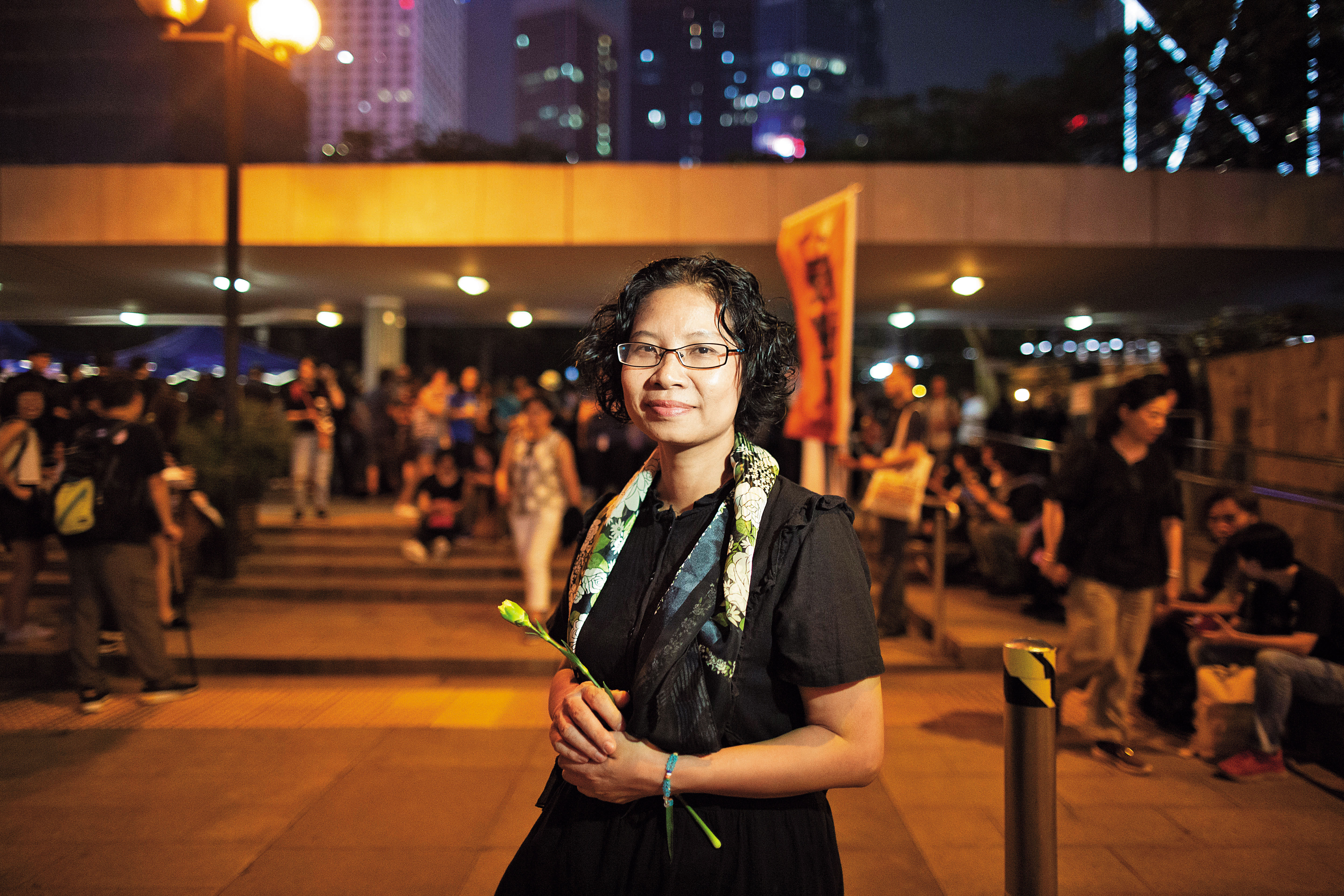 陸錦城參加香港媽媽6月14日晚上在遮打花園的集會，手持白色康乃馨。
