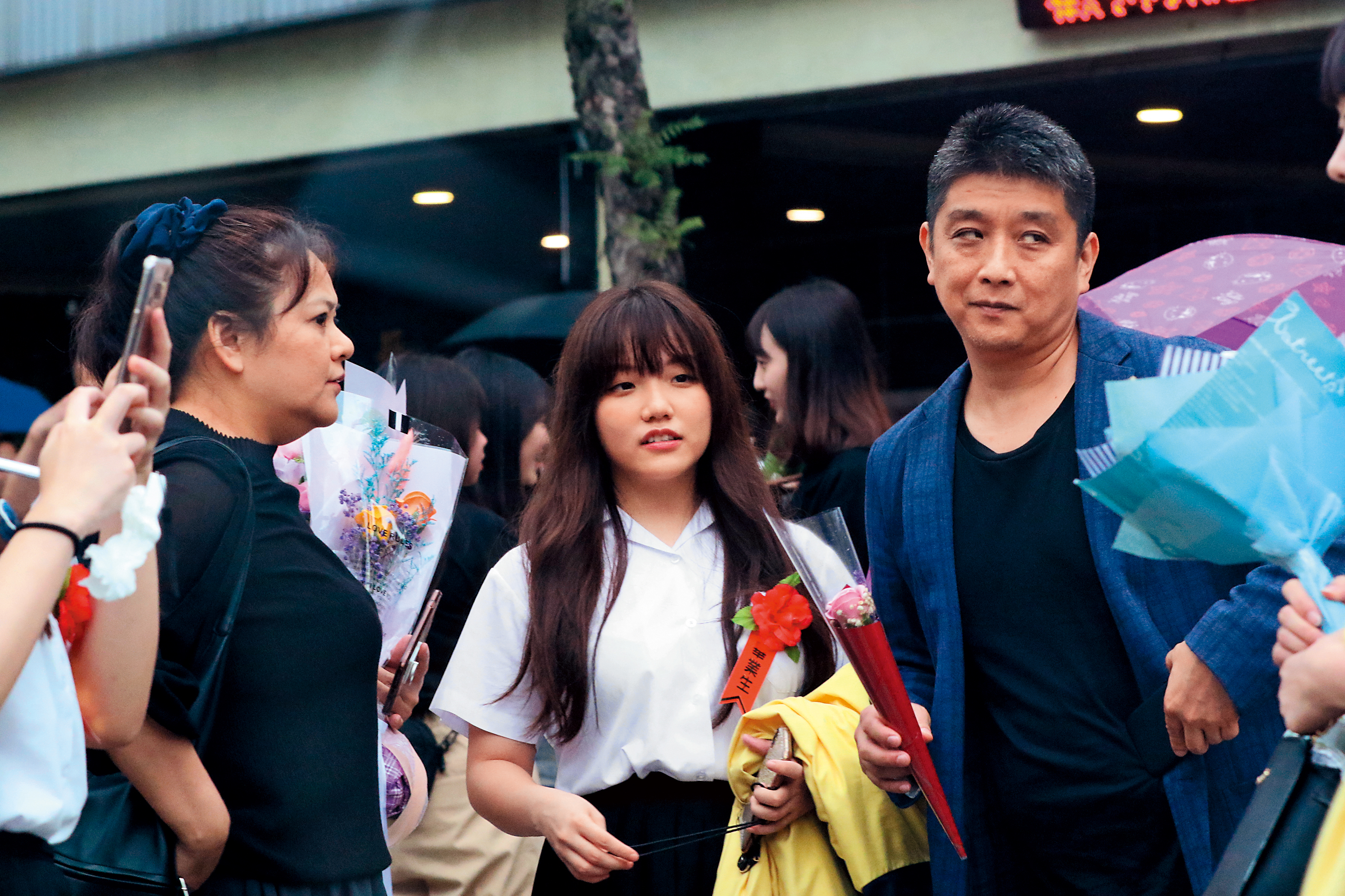 喇吻之前，安那（中）爸媽現身她的畢業典禮。安那是中日混血，父親（右）是日本人，沒戴口罩的她，看來有些膨皮。