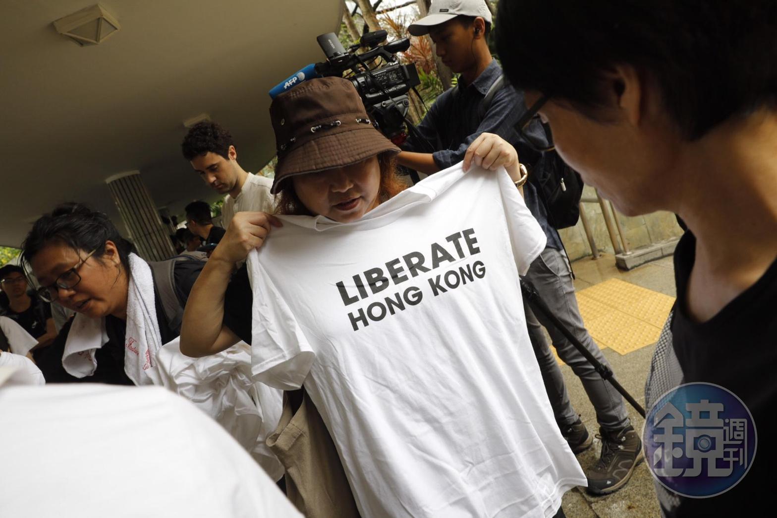 民眾手持「LIBERATE HONG KONG」的白衣。