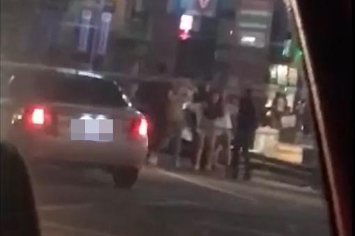 熱褲辣妹橫擋雙方人馬之間，阻止衝突發生。（翻攝畫面）