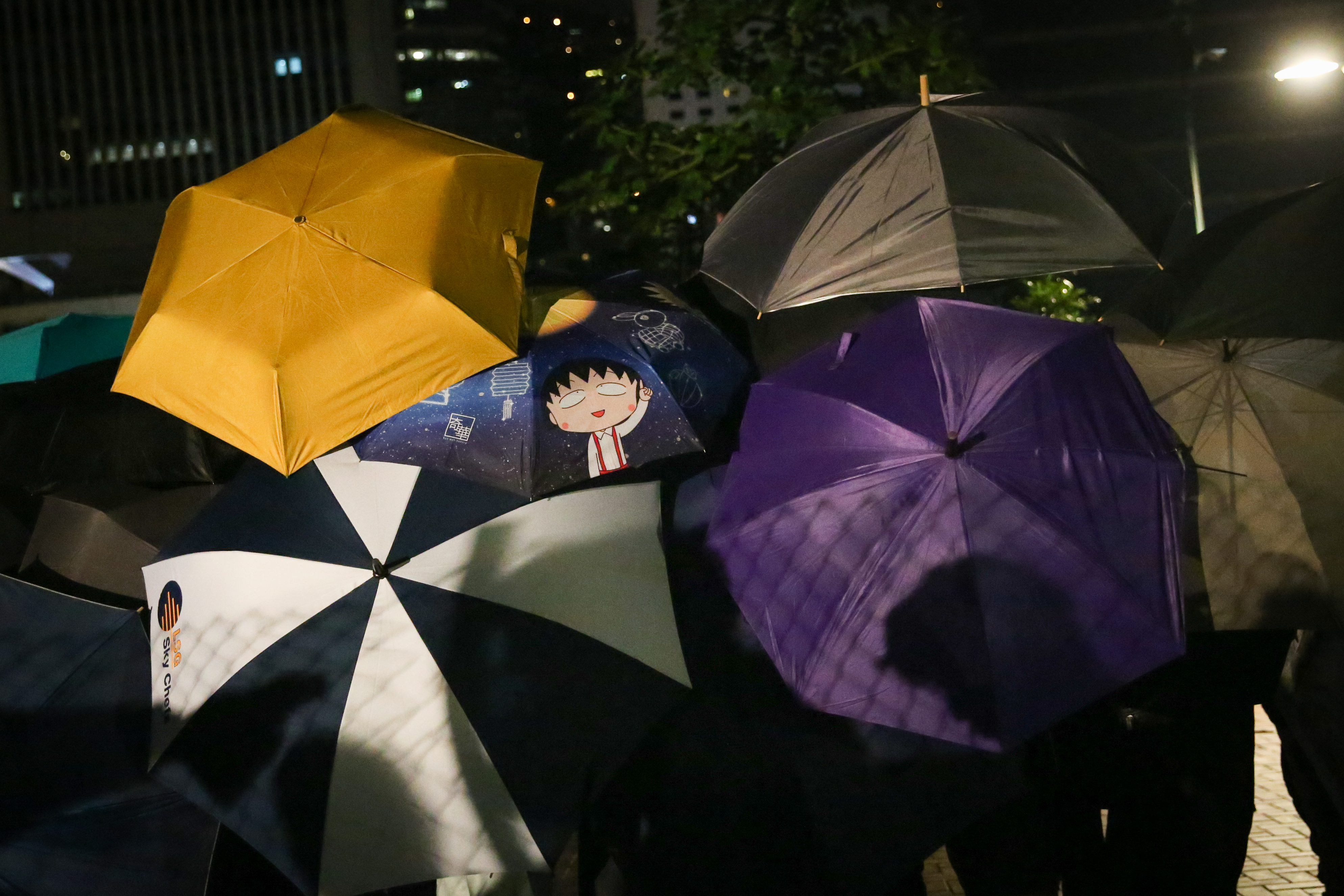 現場抗議民眾撐起傘避免被記錄下來。