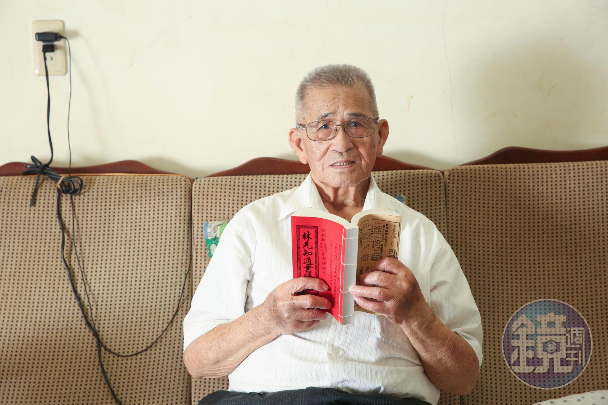 張金德手持的紅皮「通書」是從事風水、修墓工作者必備的「工具書」。他現已退休,改信基督教。