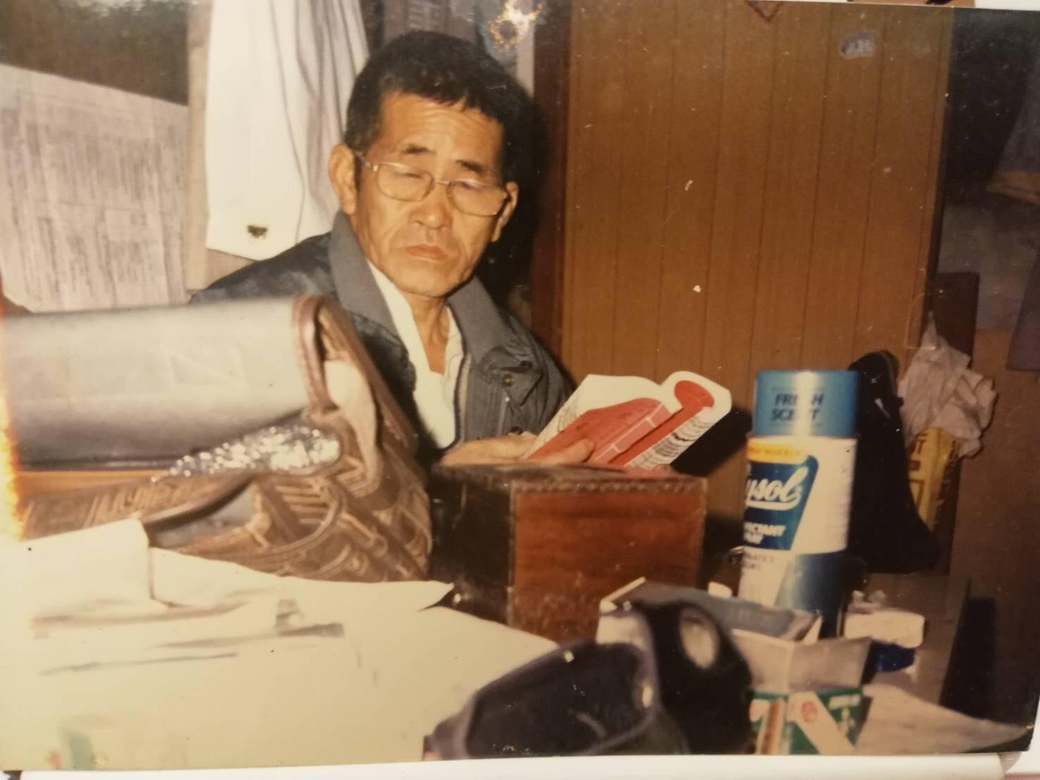 這是90年代,風水生意最好的時候,張金德在工作桌前查「通書」。(張金德提供)