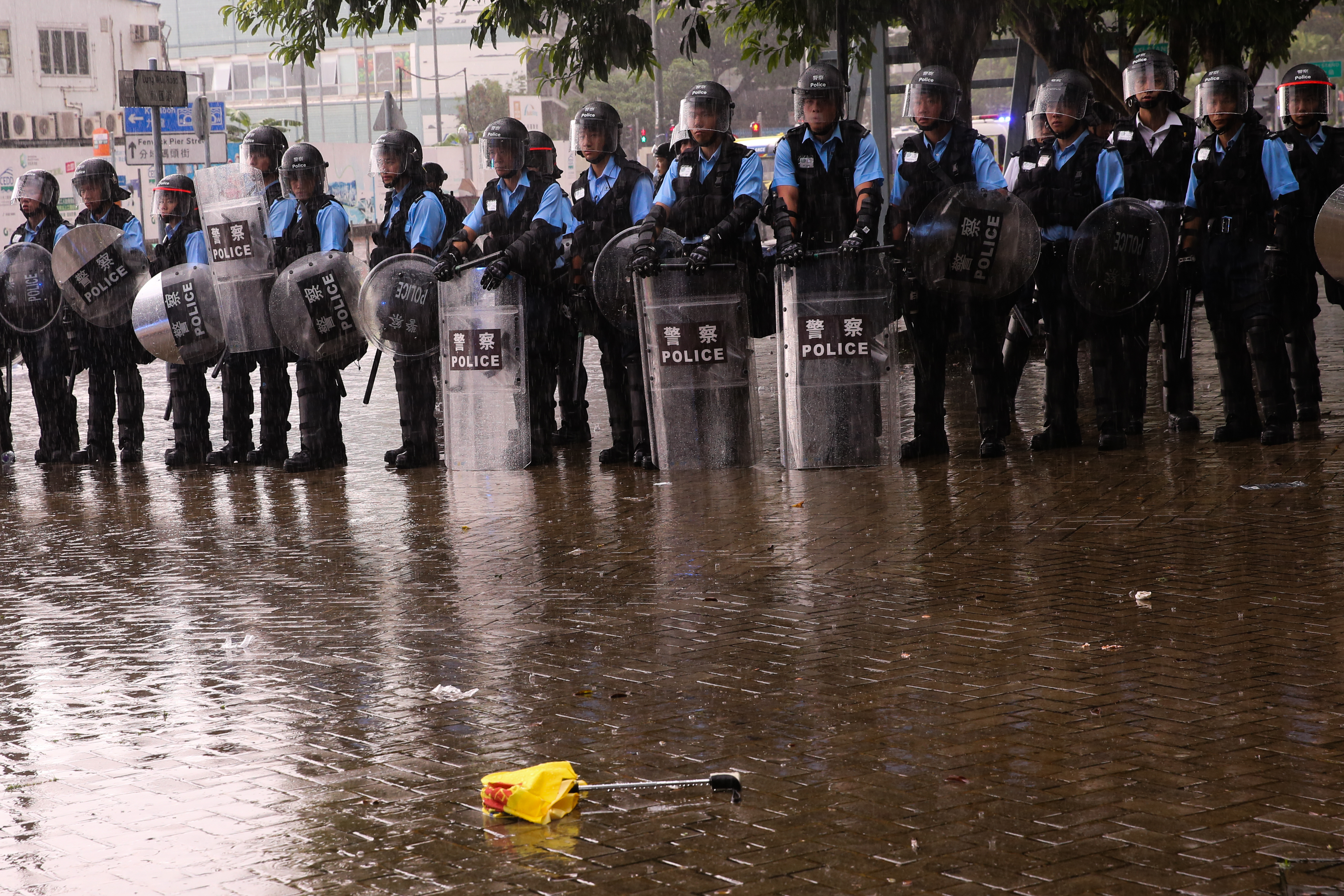 一把被毀壞的傘被棄置在警方的人牆前。