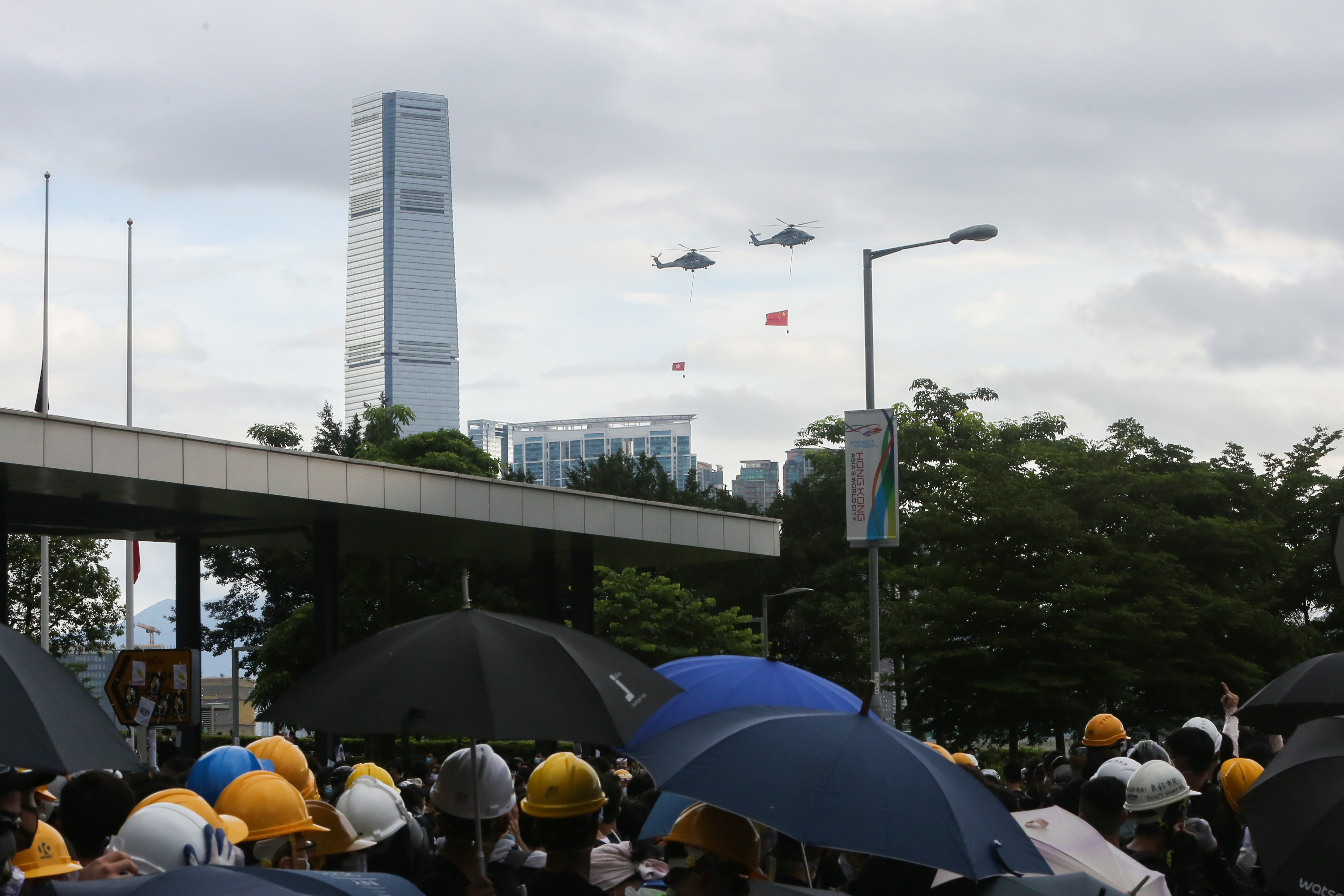 有掛著中國國旗的和香港特區區旗的直升機從金鐘抗議現場飛過。