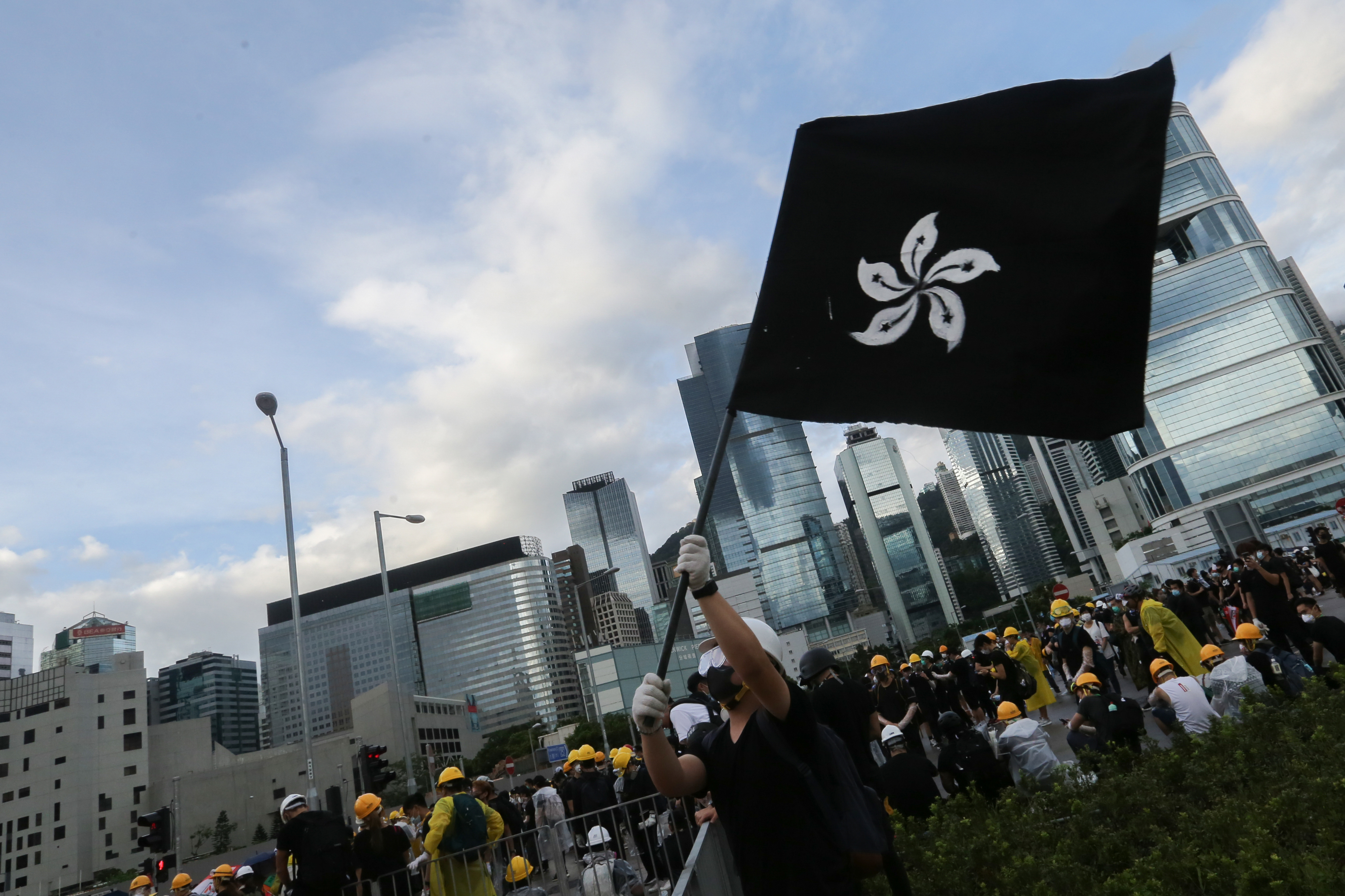一位示威者在現場高舉香港黑旗。