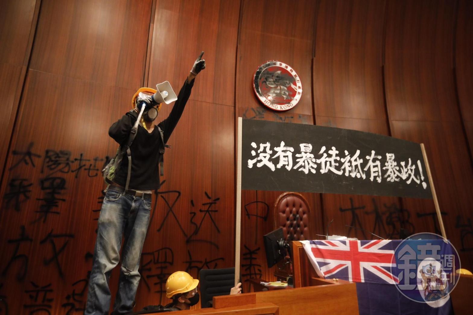 示威者突破鐵捲門，從衝撞開的鐵捲門下方搶進立法會。 （楊子磊攝）
