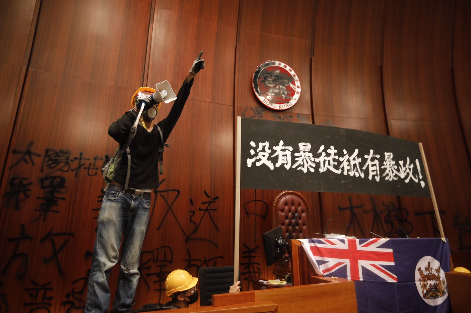 示威者突破鐵捲門，從衝撞開的鐵捲門下方搶進立法會。 （楊子磊攝）