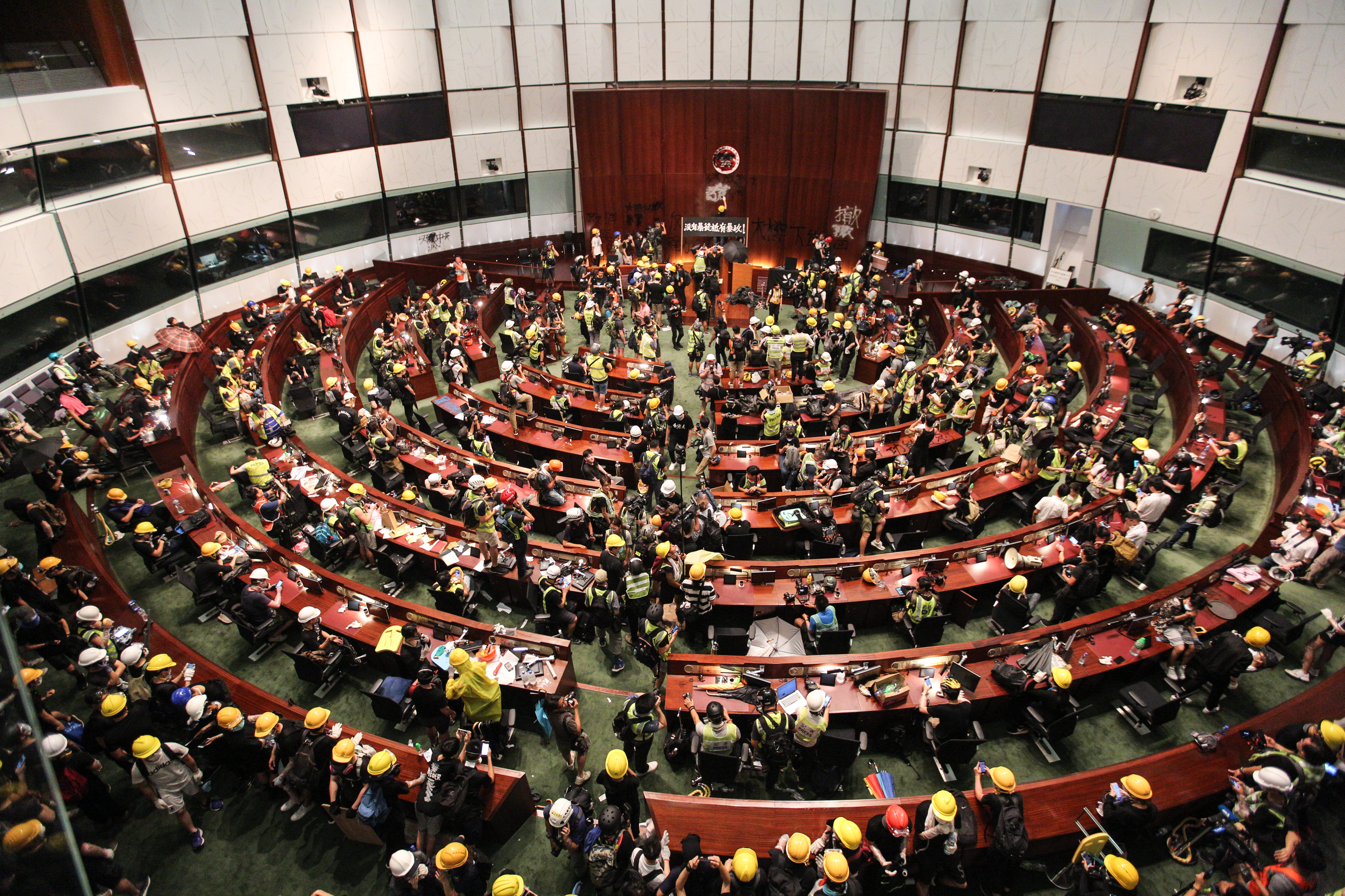 數百示威者陸續進入議事廳,噴漆寫下「撤回修例」「太陽花HK」「釋放義士」「沒有暴動,只有暴政」等與遊行無異的訴求,要求與林鄭對話。(林俊耀攝)