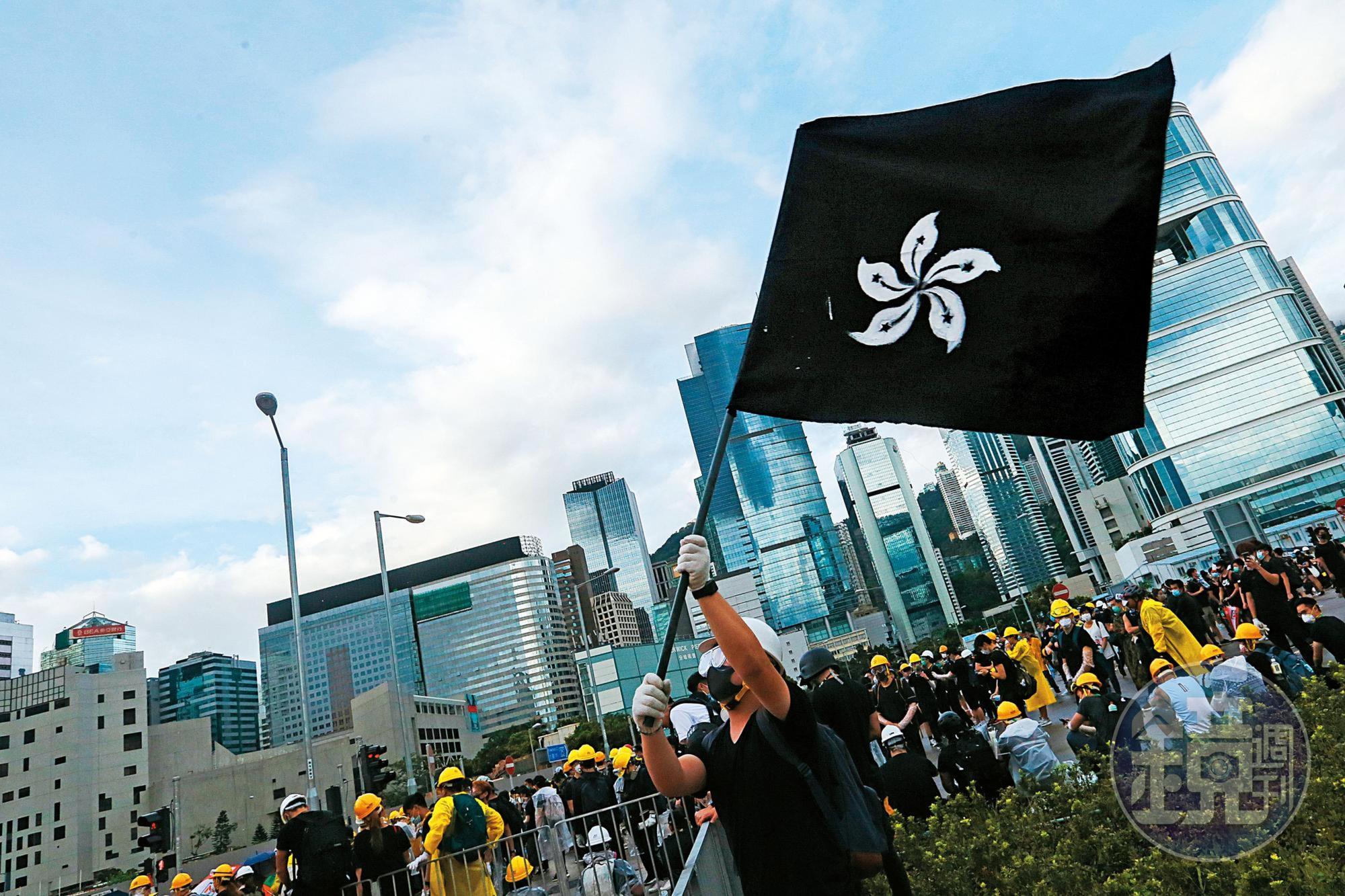 七一這天，示威者在龍和道上舉起象徵「哀悼香港民主」的香港黑旗。（林俊耀攝）