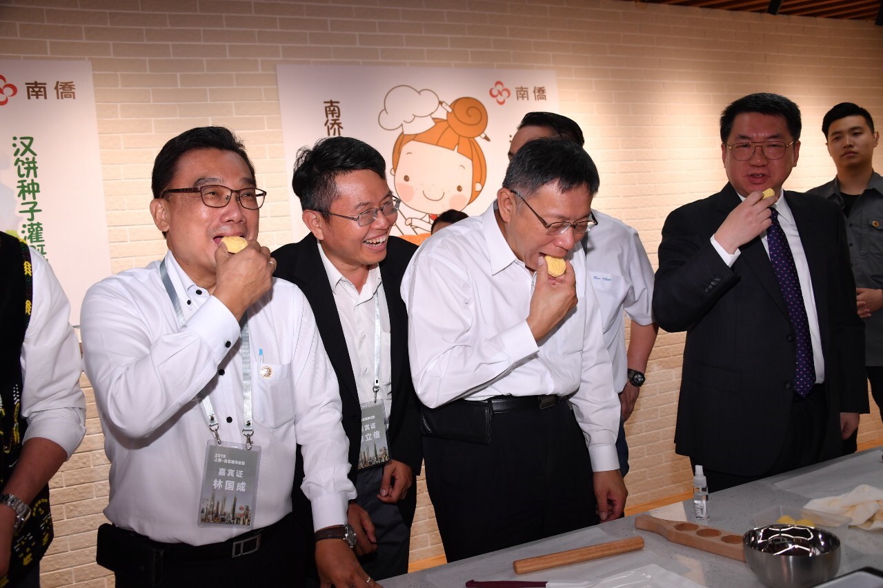 柯文哲參觀南僑集團時被拱吃「帝王酥」，議員笑說，不能叫「酥」，因為會「輸」。（北市府提供）
