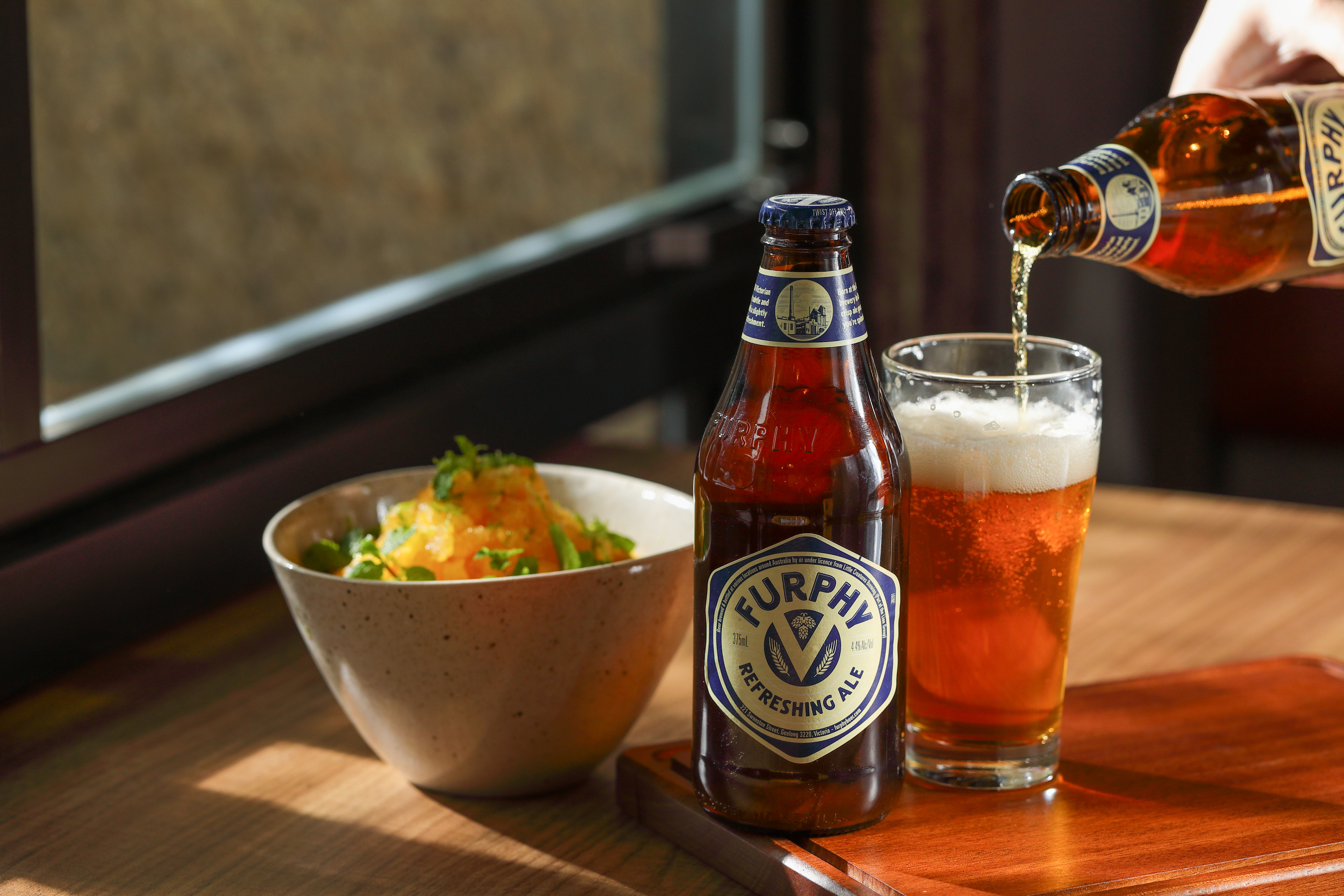 澳洲當地原料釀造的「Furphy清爽艾爾」（右，130元／瓶）可延續澳式經典甜點「帕芙洛娃蛋白霜」（左，180元／份）裡的果香。