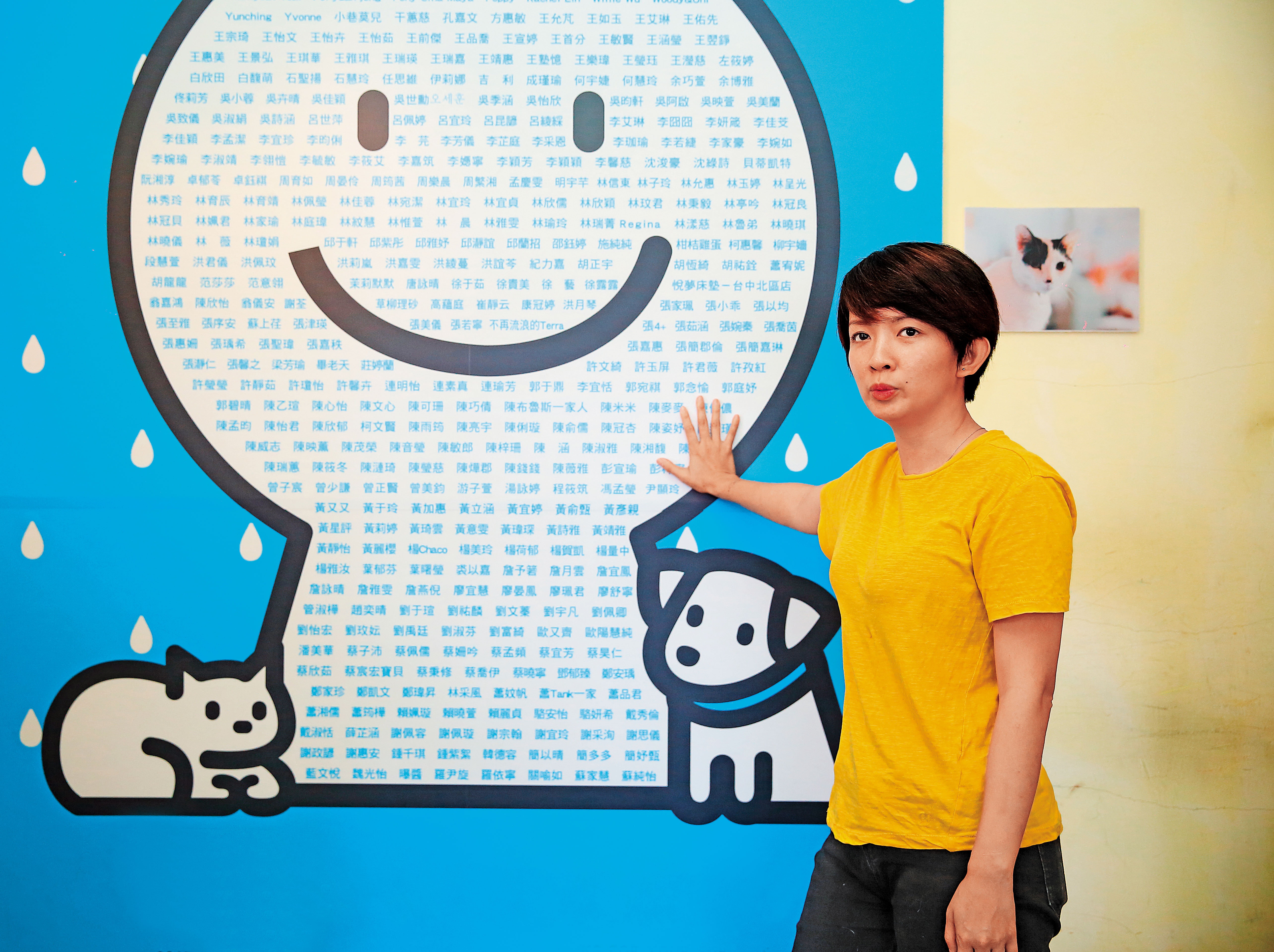 四年前，譚柔創立「浪浪別哭」，借助行銷專長，以影像包裝流浪動物，二年後又透過群眾募資開設台中店，牆上為部分捐贈者名單。