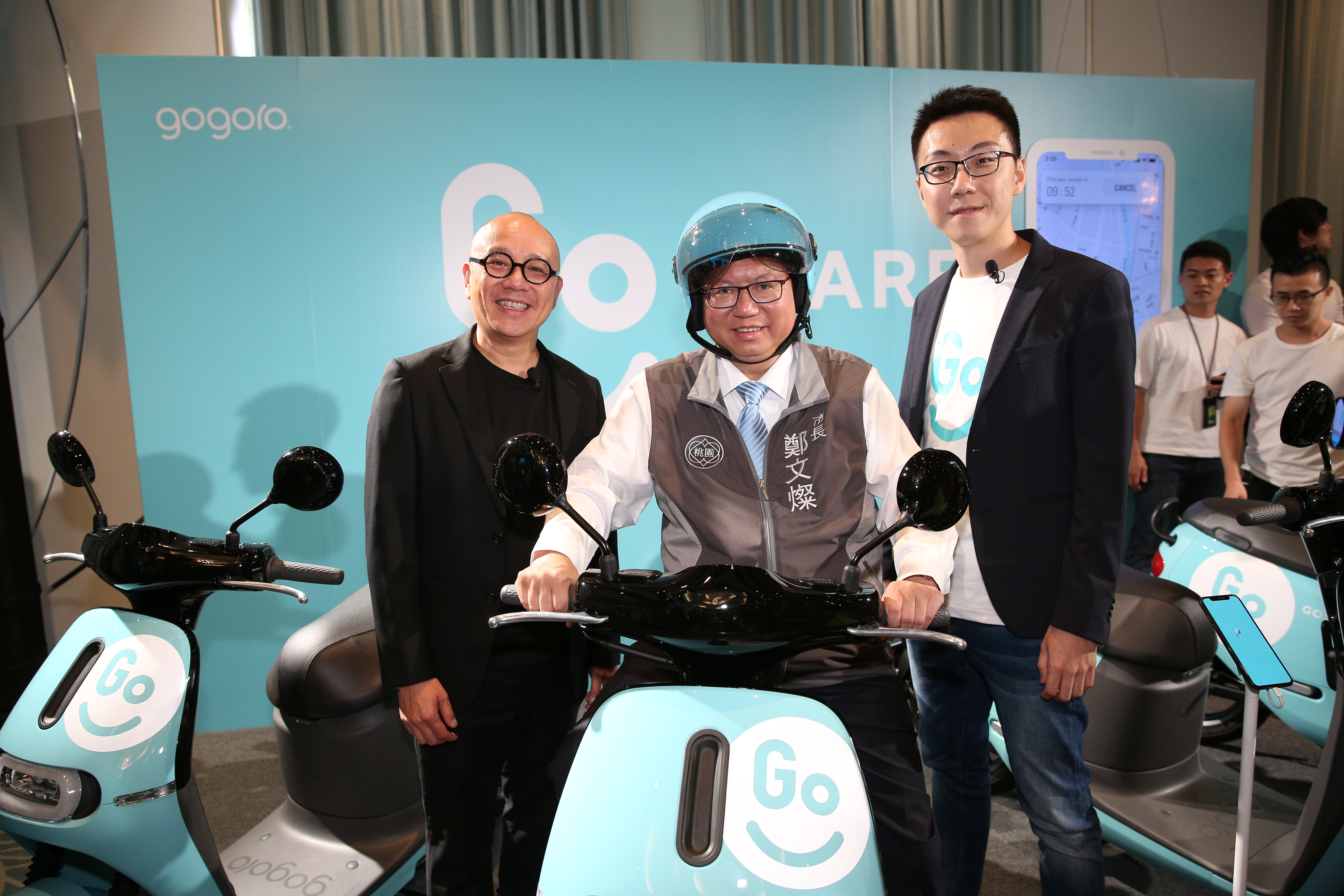 Gogoro創辦人陸學森(左)向桃園市長鄭文燦(中)介紹GoShare租賃共享服務。