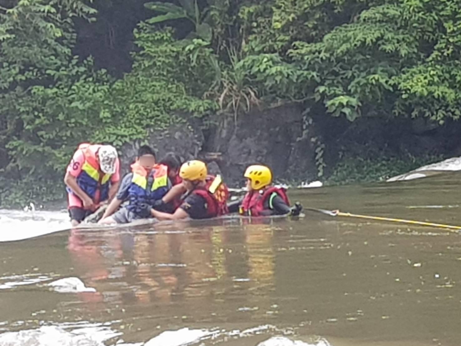 新北市警消搶救在北勢溪中被暴漲大水沖走和圍困民眾。(翻攝畫面)