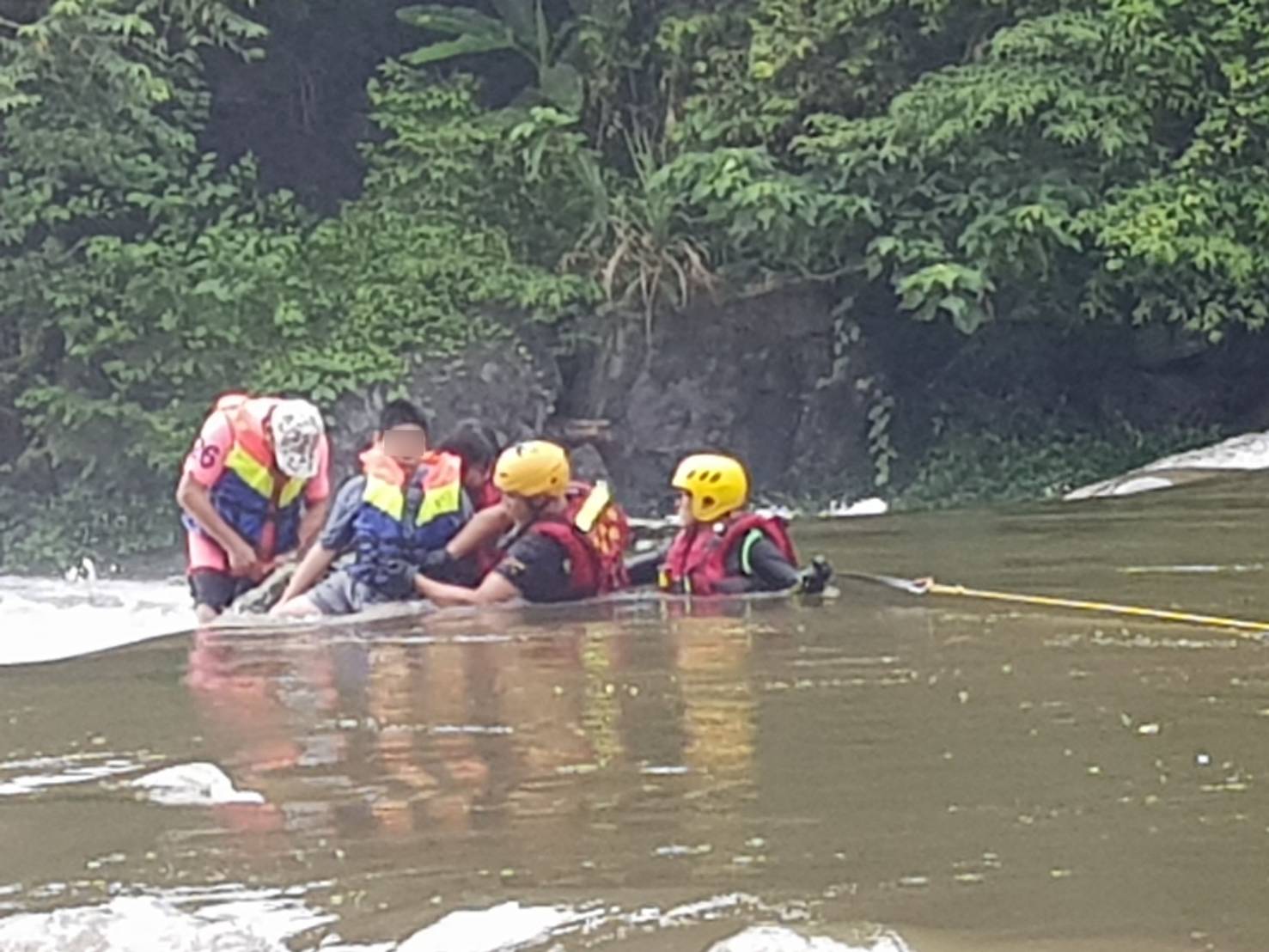 新北市警消搶救在北勢溪中被暴漲大水沖走和圍困民眾。（翻攝畫面）