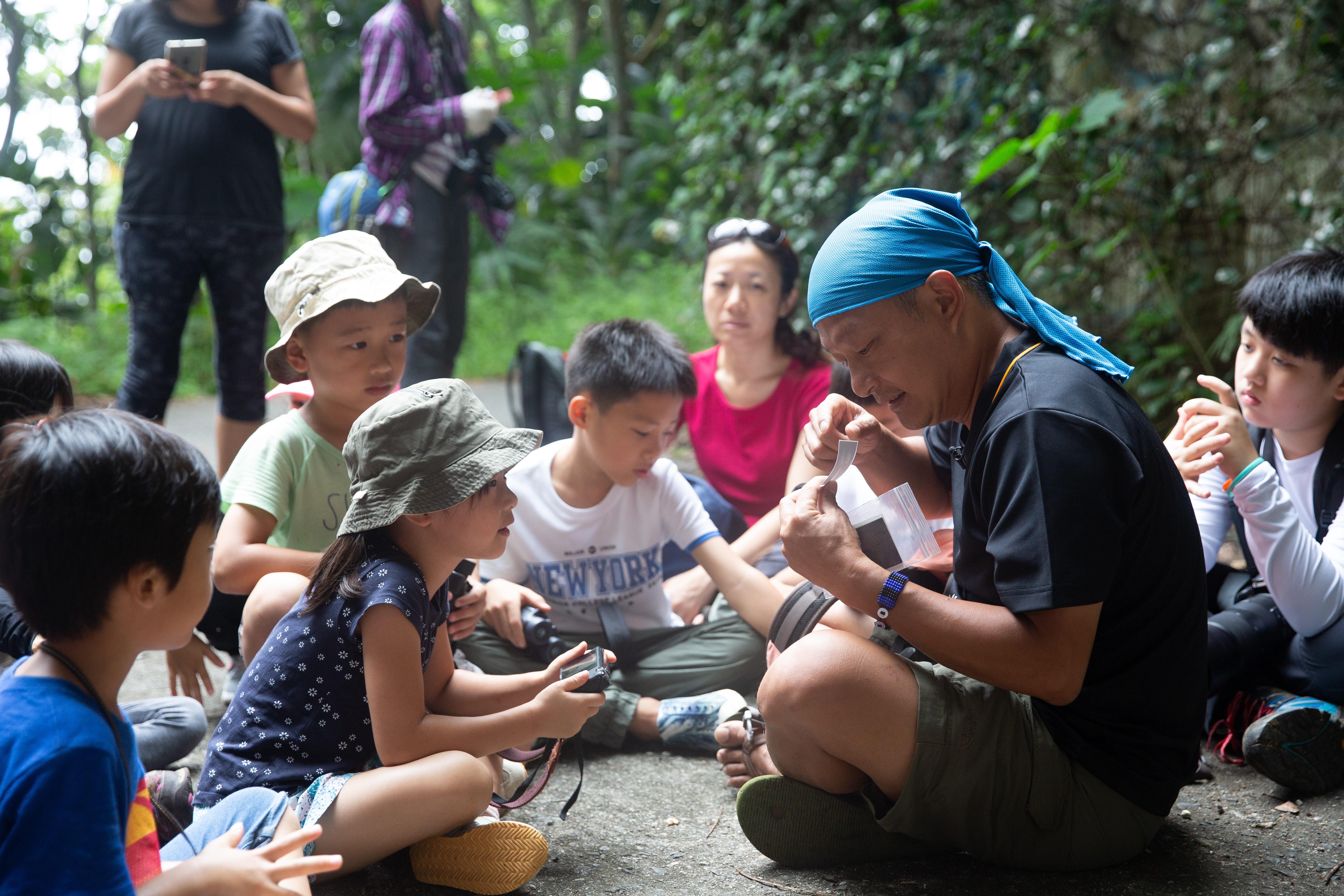 生態導覽行程第二天，林青峰（右二）會以貼紙做為人人有獎的問答，複習前日找到的動物。