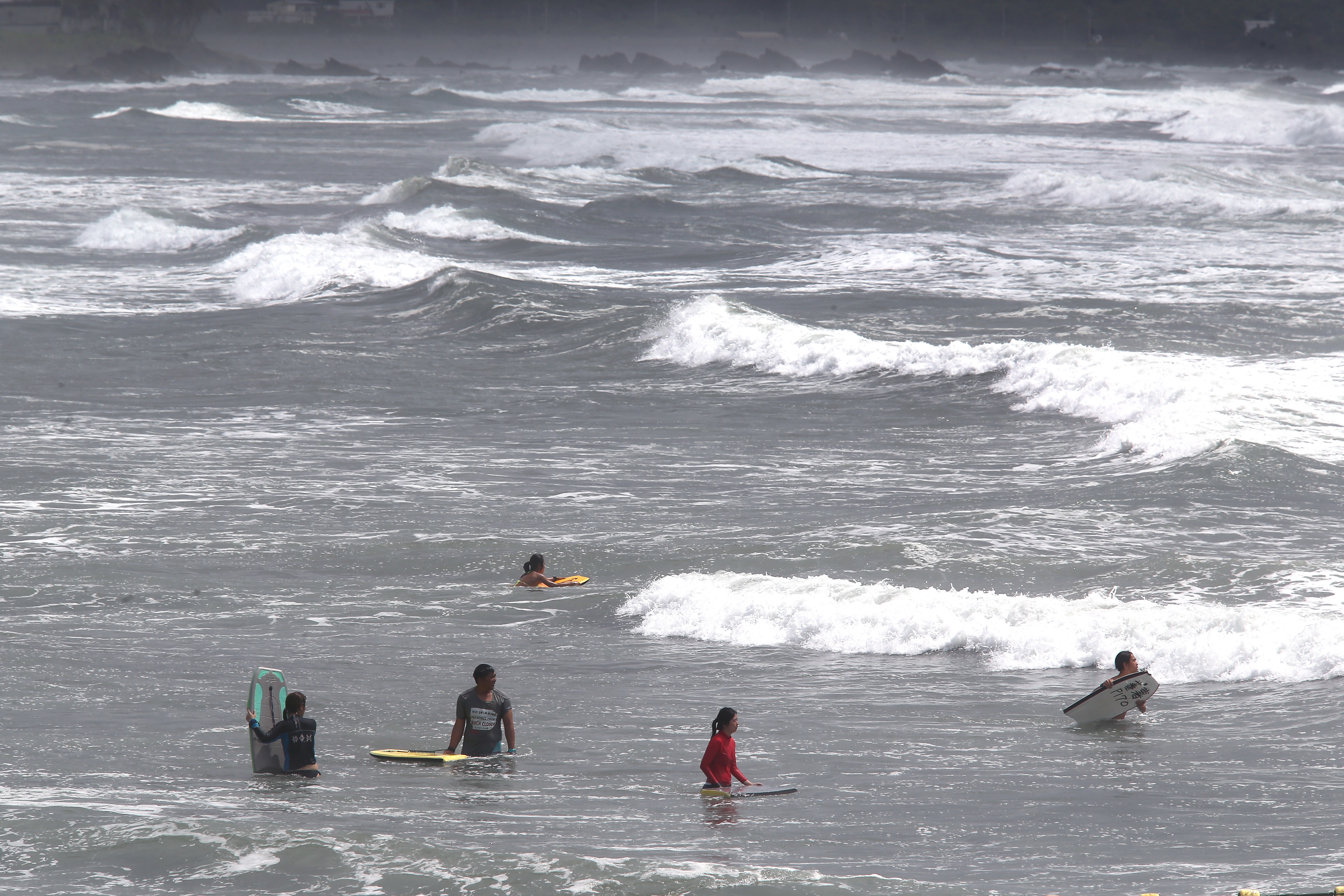 颱風天仍有不少人不顧海巡與警察勸阻，硬要到海邊衝浪。（東方IC）