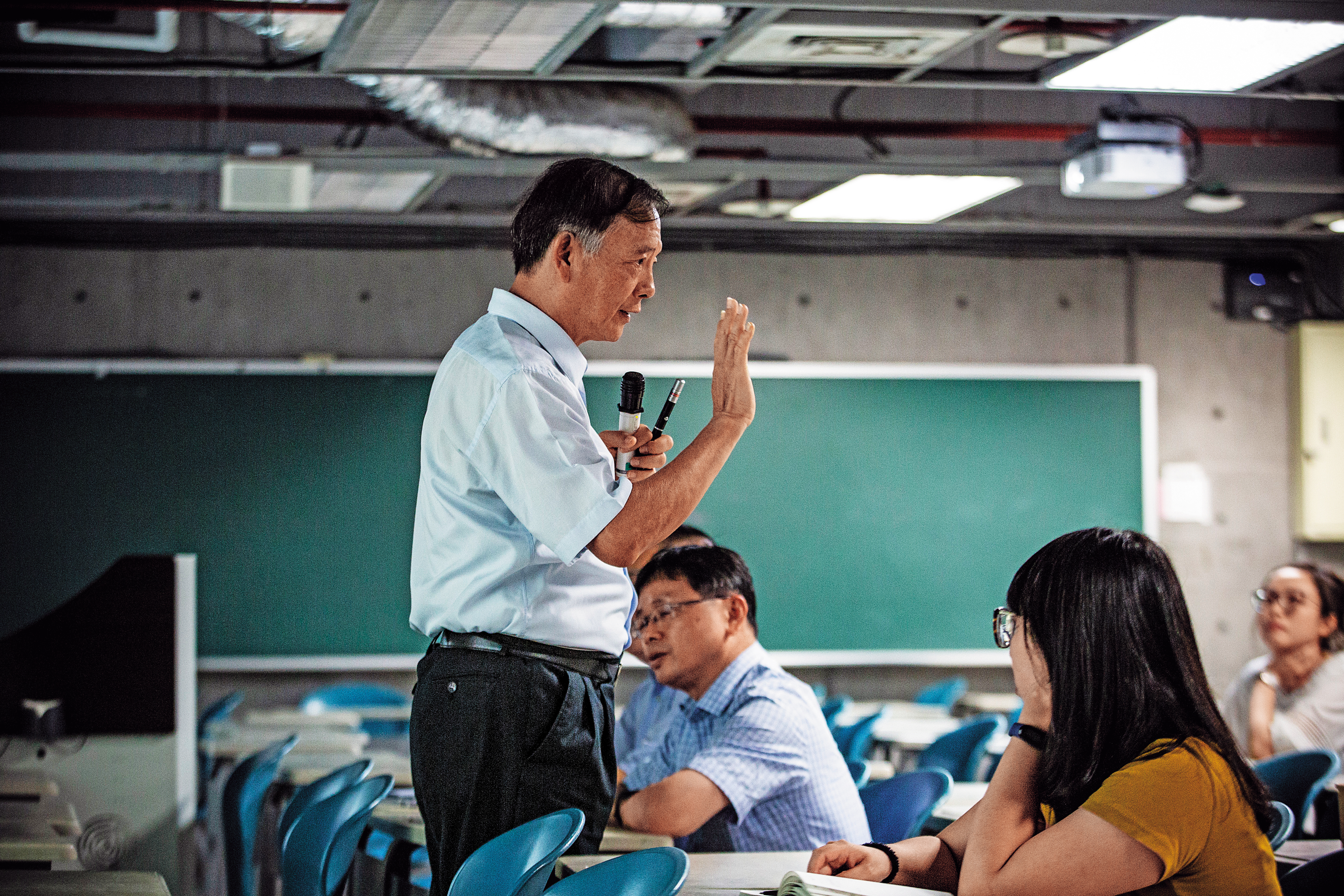 儘管王隆昌（立者）已經無法受聘為專任教授，但北科大的老師仍經常邀他回課堂演講教課，回到熟悉的講台上，他就充滿自信與光采。