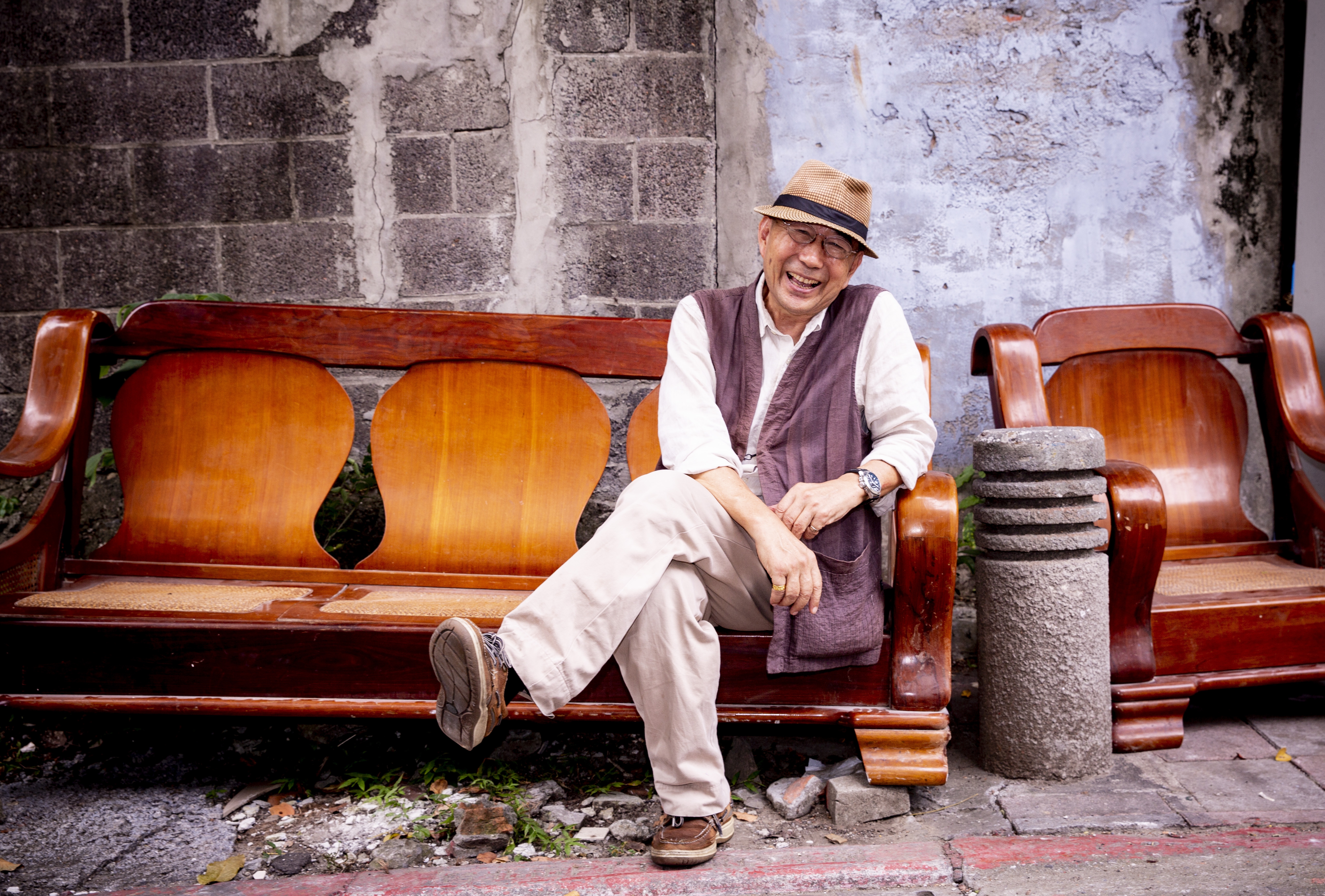 黃英雄很隨和，我們在路邊一處廢棄的椅子拍照，他不在乎椅子上的灰塵就要直接坐上去，還自嘲坐在這邊拍照有荒謬的美感。