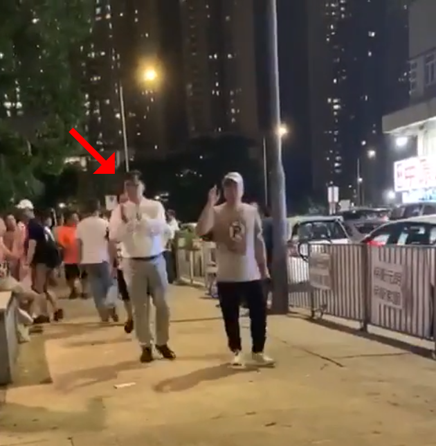議員何君堯向白衣人走去，一路拍拍手。（翻攝自網路影片）