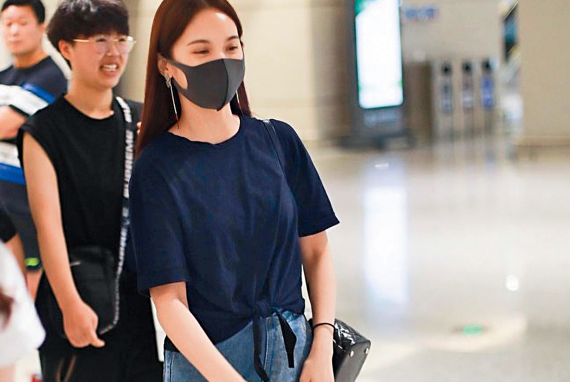 7月16日有讀者直擊，楊丞琳穿著黑色T恤、牛仔裙，並戴著口罩飛到大陸探李榮浩的班，雖一身樸素打扮，仍被人認出。（讀者提供）